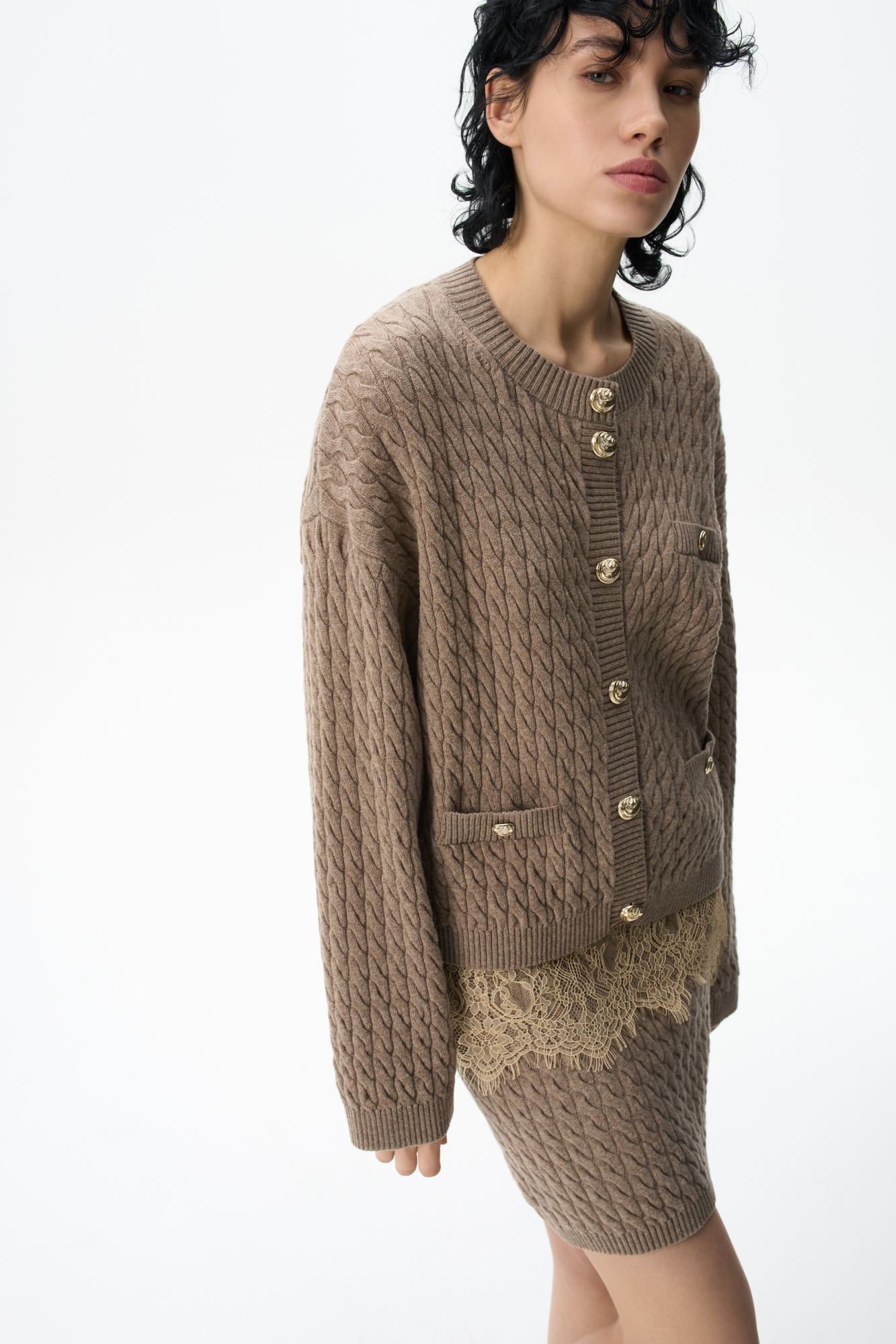 Кардиган из 100% шерсти мериноса экстрафайн, выполненный вязкой косами. Модель свободного кроя с длинными рукавами, спущенной линией плеч и круглым вырезом горловины. Имитация карманов с клапанами. Изделие декорировано крупными акцентными пуговицами.