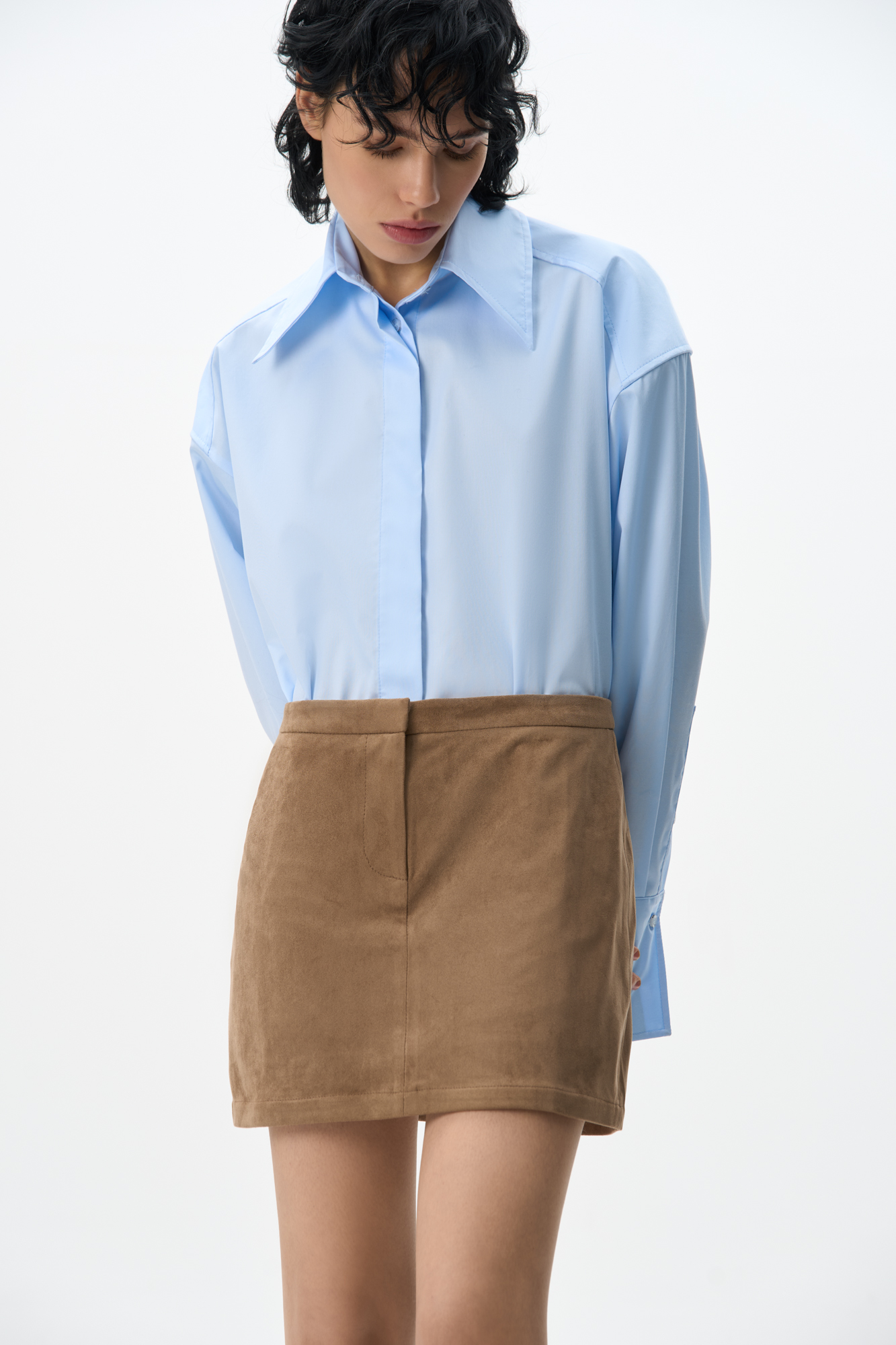 Юбка длины мини из ткани с имитацией внешнего вида и свойств натуральной замши. Застежка на скрытую пуговицу и молнию спереди. 