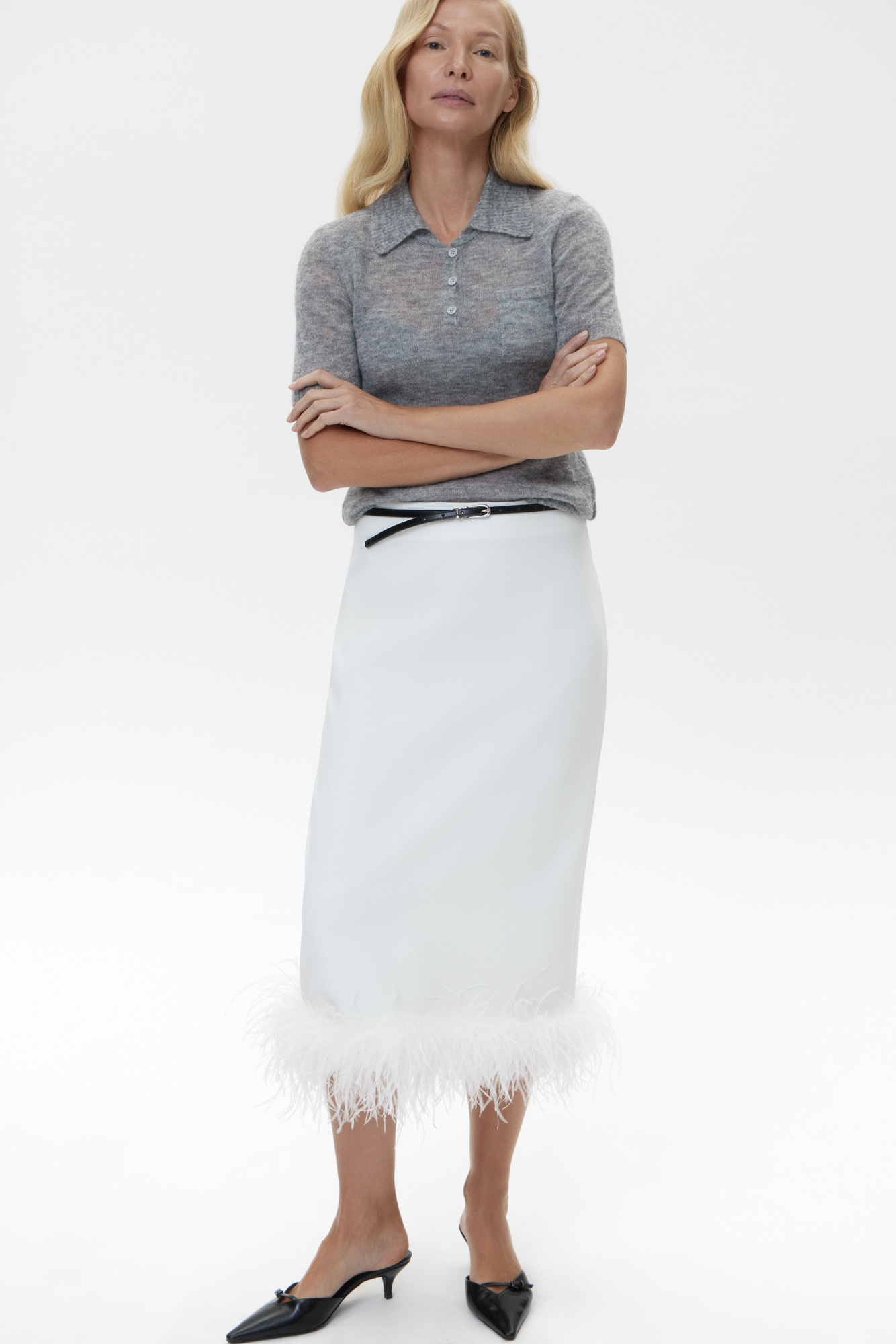 Прямая юбка миди из вискозы. Модель прямого кроя, с разрезом сзади и застежкой на молнию. Изделие декорировано страусиными перьями на подоле. Лента с перьями отстегивается. 