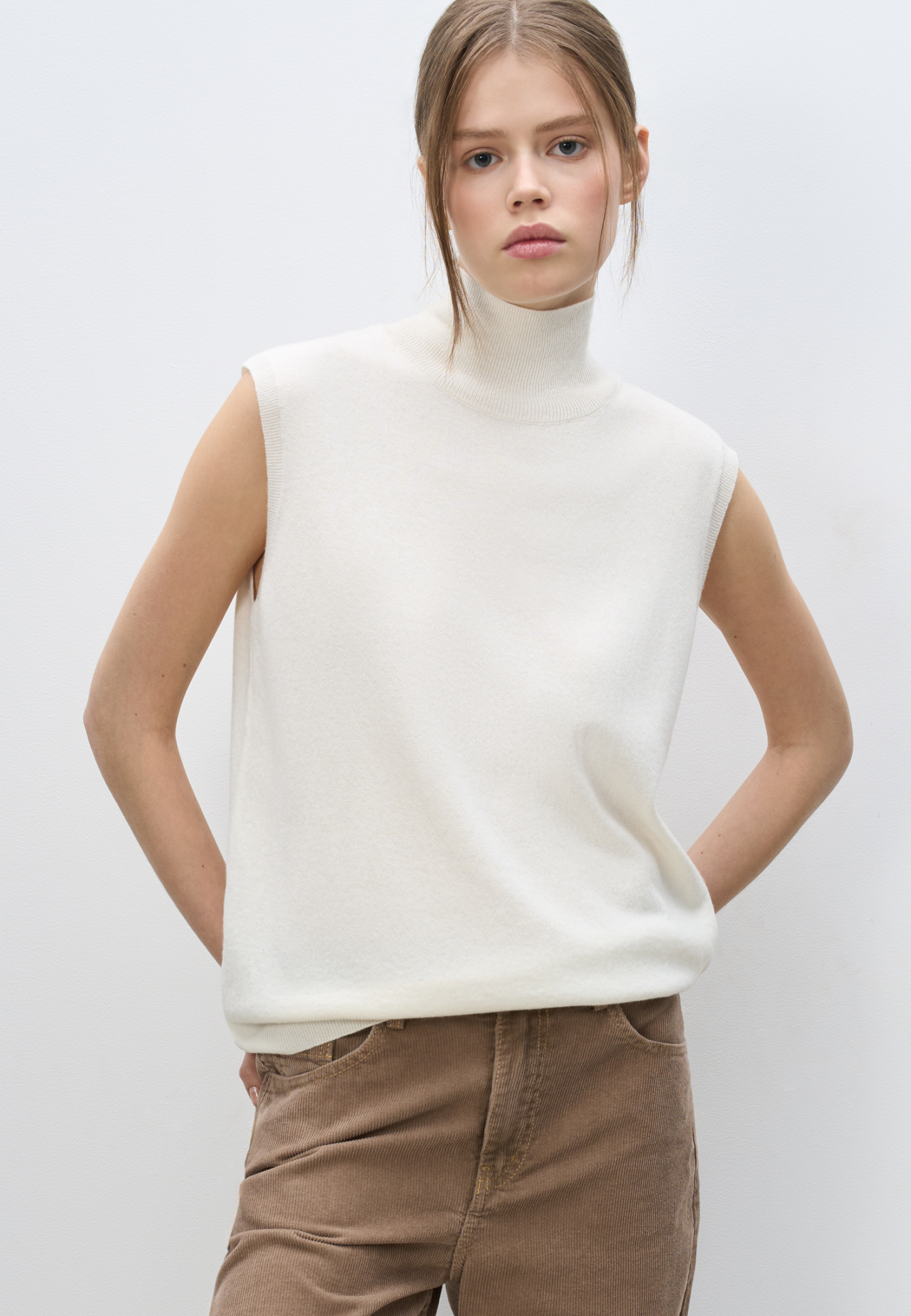 Трикотажный жилет из кашемира и шерсти. Модель без рукавов с воротником-стойкой, выполненным в тонкий рубчик.