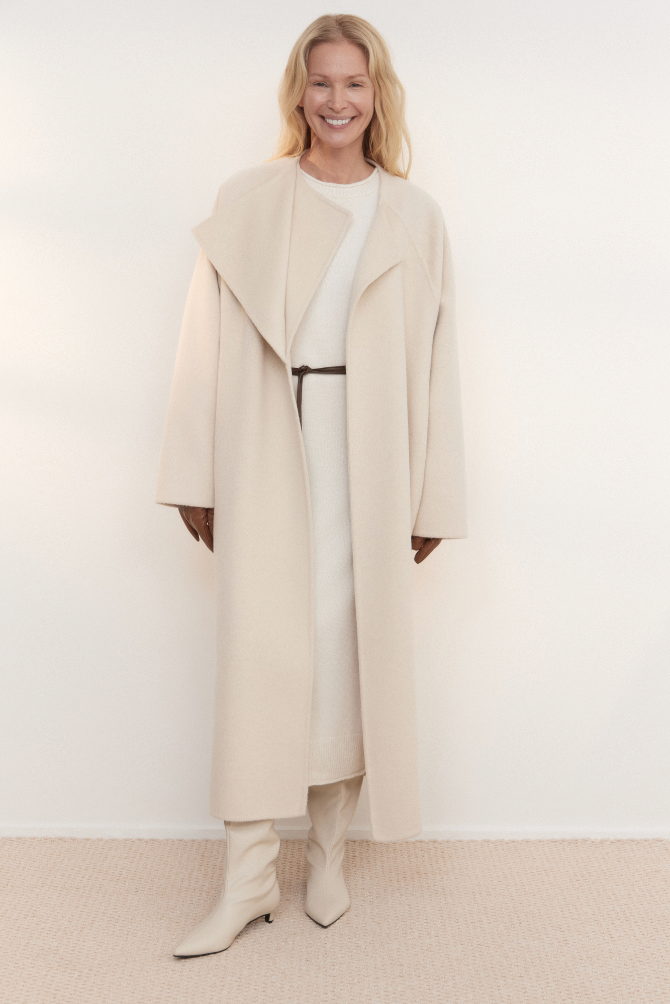 Шерстяное пальто из двусторонней ткани. Модель прямого кроя без воротника. Застежка на скрытые магнитные пуговицы. Изделие без подкладки. Модель декорирована асимметричным лацканом. Пояс из экокожи в комплекте.