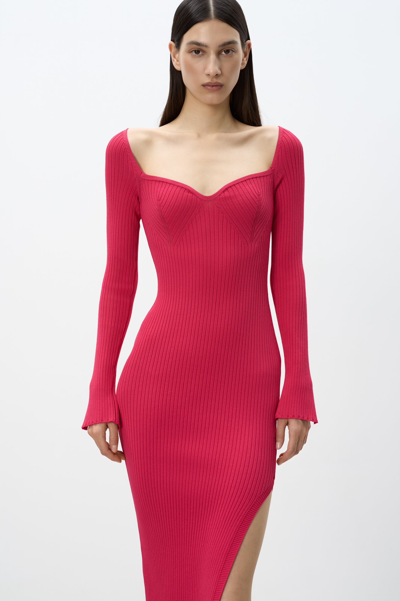 Трикотажное платье из вискозы длины миди. Модель приталенного силуэта, с длинным рукавом, глубоким вывязанным декольте с вытачками и разрезом сбоку.