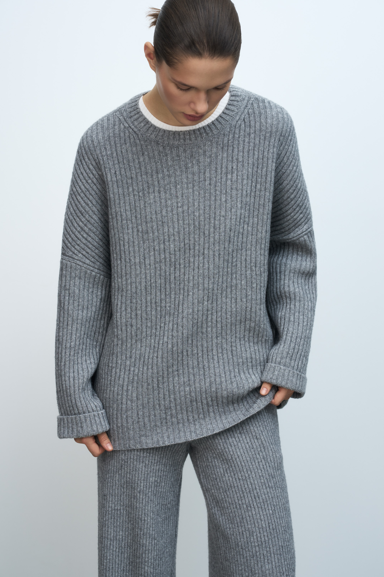 Трикотажный джемпер из шерсти с добавлением кашемира. Модель свободного силуэта со спущенной линией плеча, отворотами на манжетах и круглым вырезом горловины. Изделие выполнено в широкий рубчик.