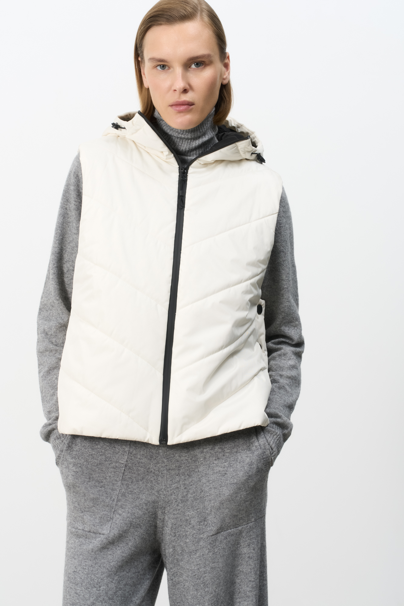 Oversize жилет на синтепоне с капюшоном. Модель свободного силуэта с застежками на кнопки по бокам и молнию.