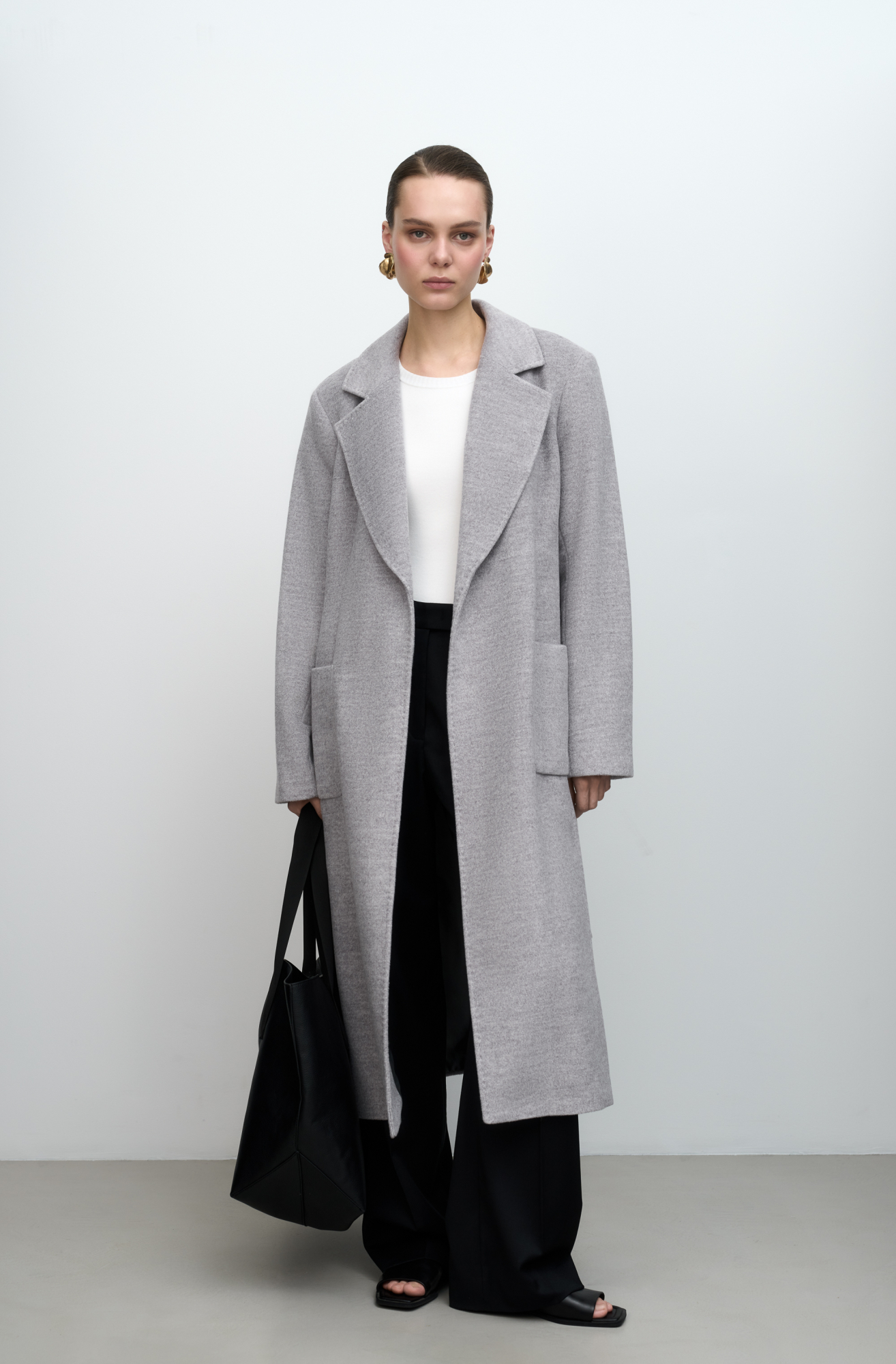 Классическое шерстяное пальто с поясом из основной ткани. Модель приталенного силуэта. Отложной воротник с прямоугольными лацканами и накладные карманы. 