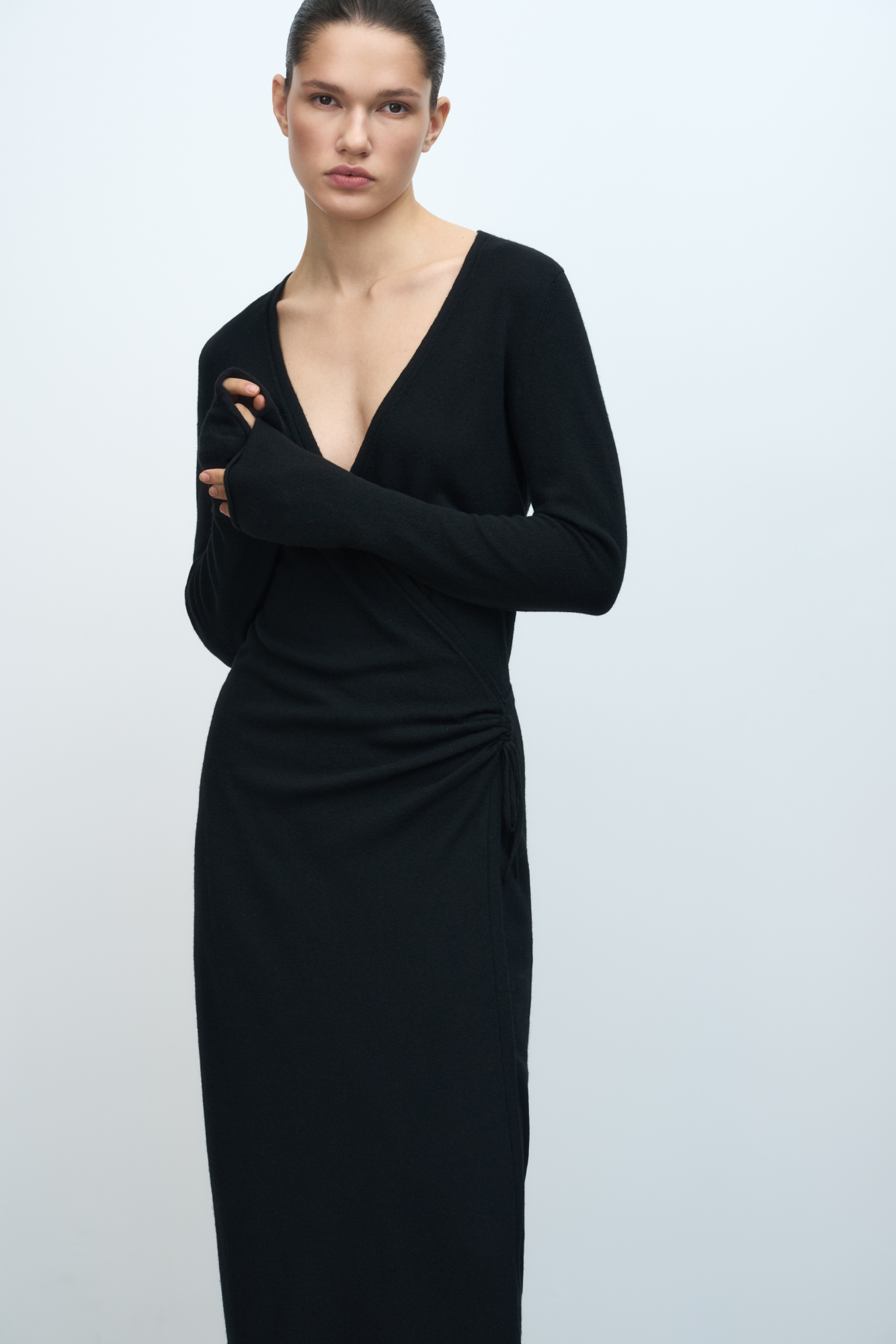 Трикотажное платье на запах из шерсти и кашемира. Модель приталенного силуэта с V-образным вырезом, длинными рукавами и кулиской на талии. Подол платья и манжеты рукавов декорированы валиками.