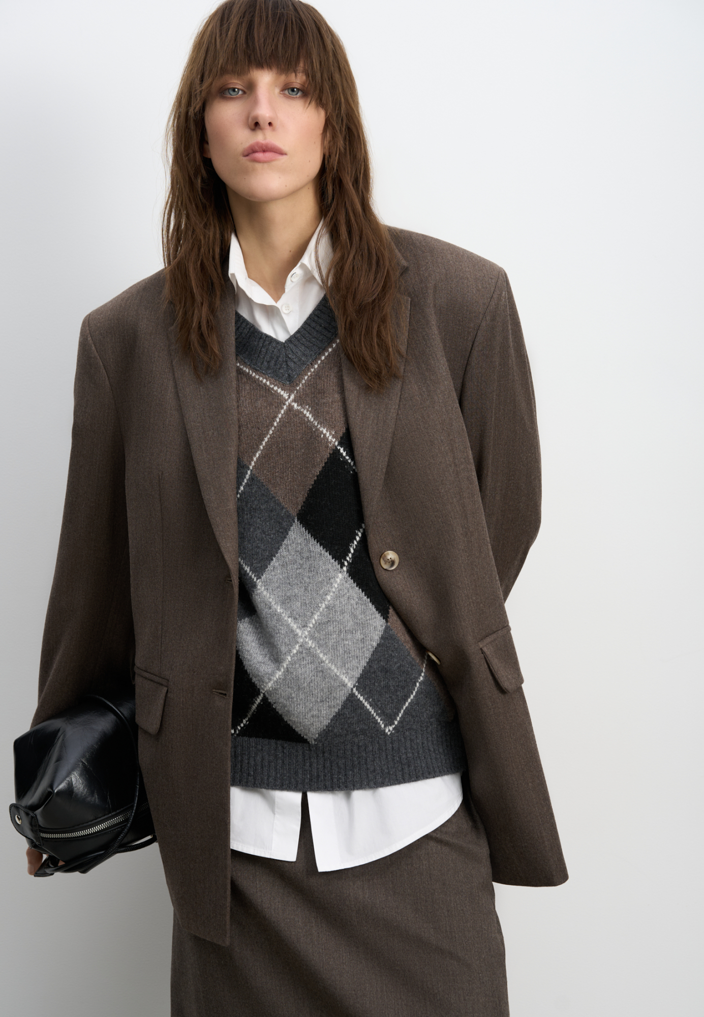 Трикотажный жилет из кашемира с узором аргайл. Модель свободного силуэта без рукавов с неглубоким V-образным вырезом горловины. Края изделия выполнены в рубчик.