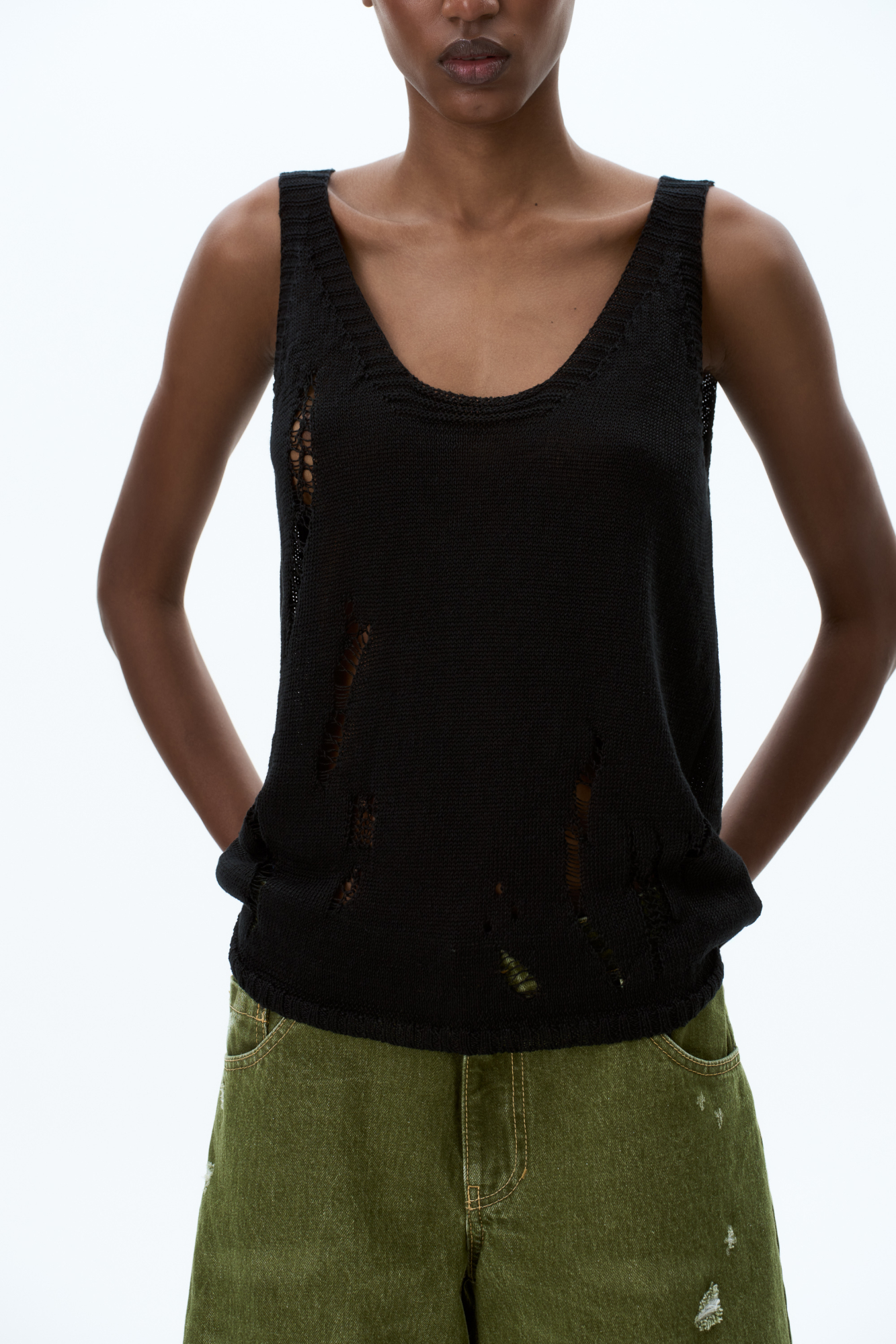 Трикотажный топ из 100% льна. Модель свободного силуэта, с глубокой проймой и U-вырезом горловины. Изделие выполнено с эффектом рвани.