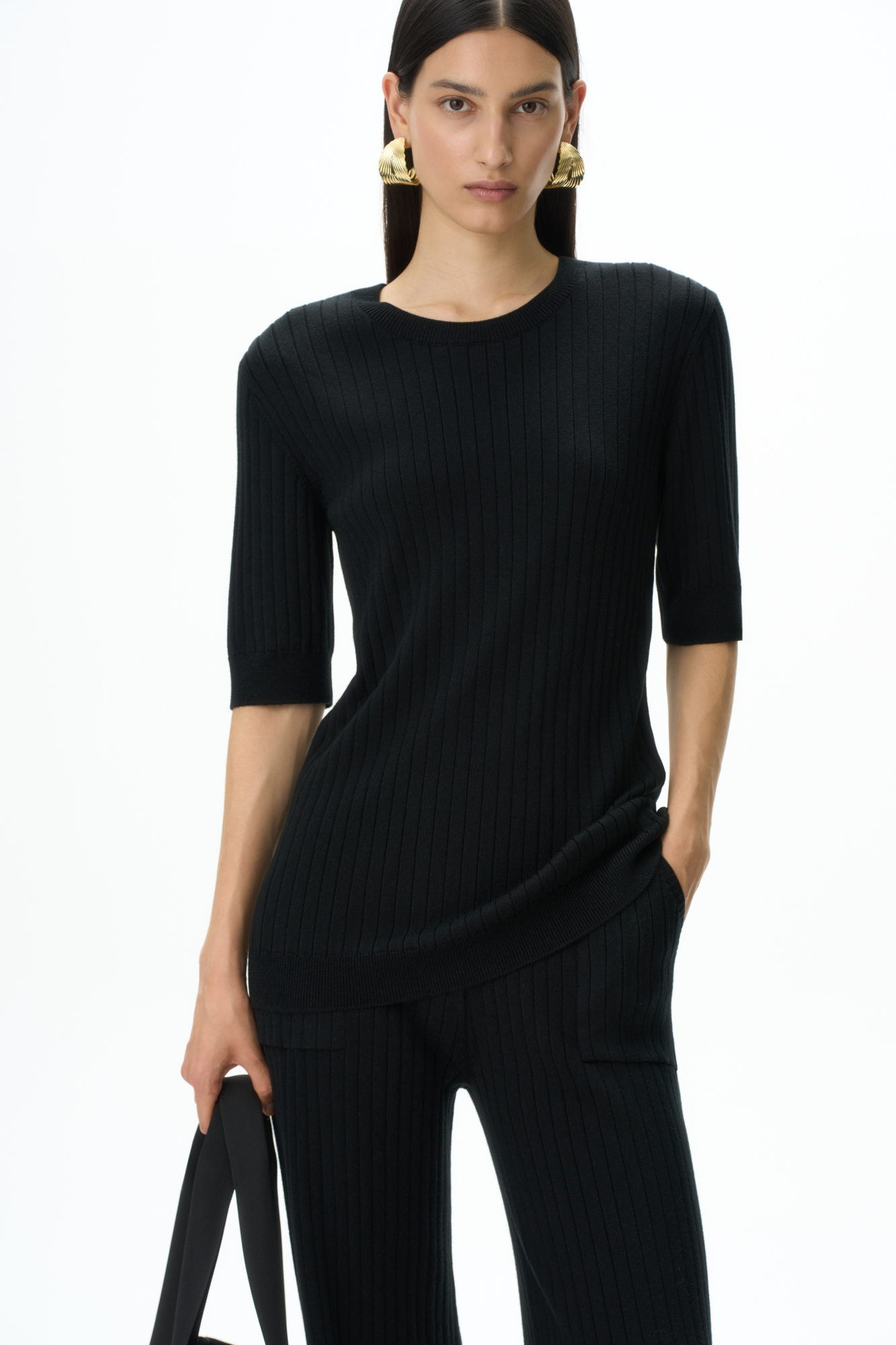 Удлиненная трикотажная футболка из хлопка с добавлением вискозы. Модель свободного силуэта. со спущенной линией плеча и круглым вырезом горловины. Дополнить образ можно брюками.