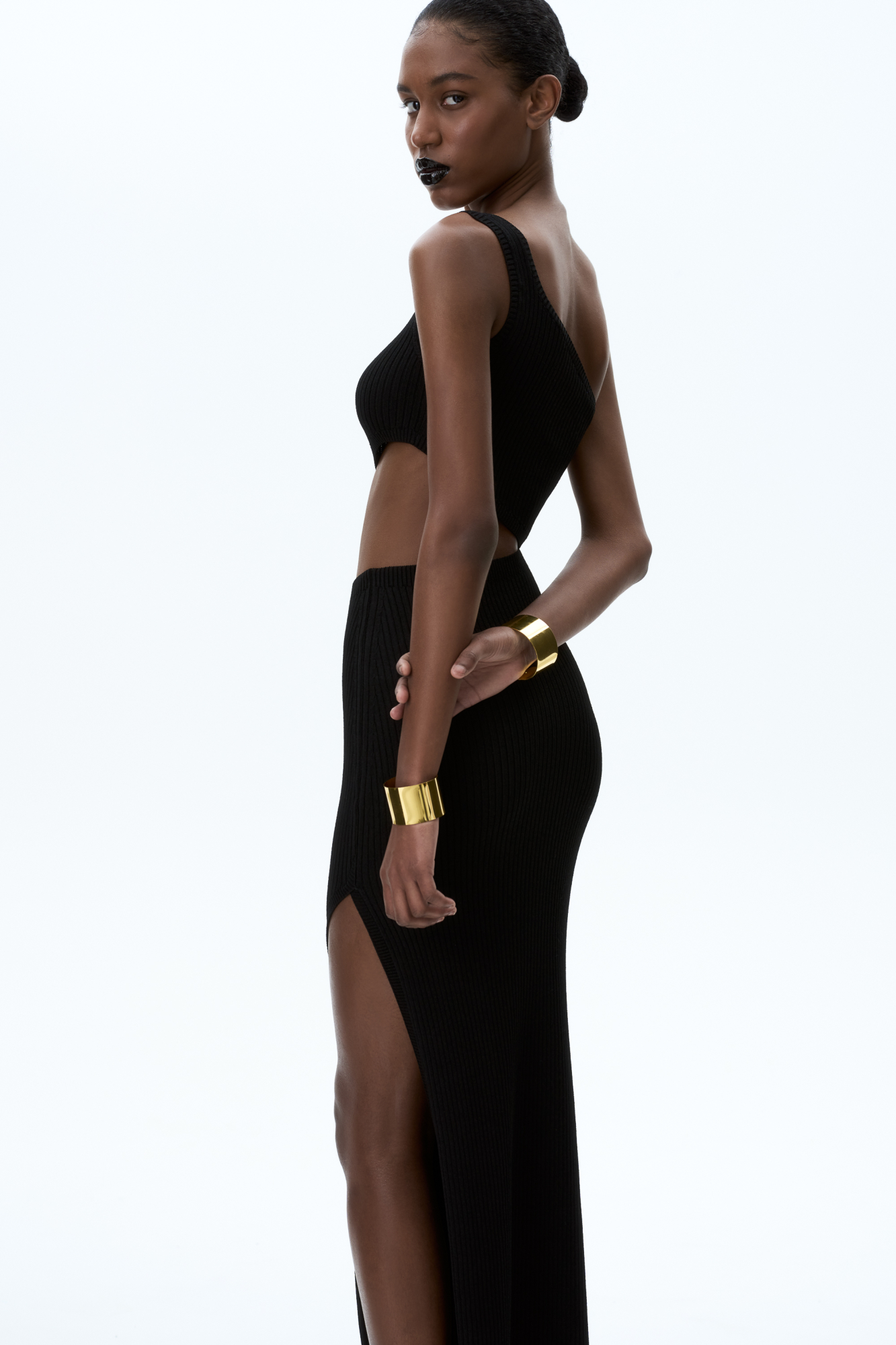 Трикотажное платье длины миди из вискозы в рубчик. Модель приталенного силуэта асимметричного кроя, с акцентным вырезом на талии, высоким разрезом на бедре и широкой бретелькой на одно плечо.