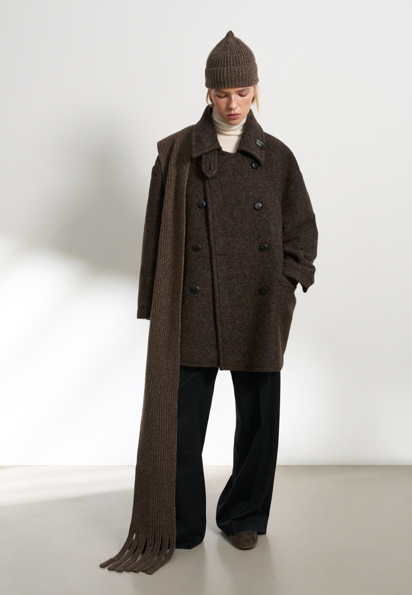 Двубортное пальто из шерсти. Модель прямого кроя со спущенной линией плеч, карманами на груди и накладными карманами с клапанами. Застежка на пуговицы. Изделие декорировано брендированными ярлыками на воротнике. На подкладке.