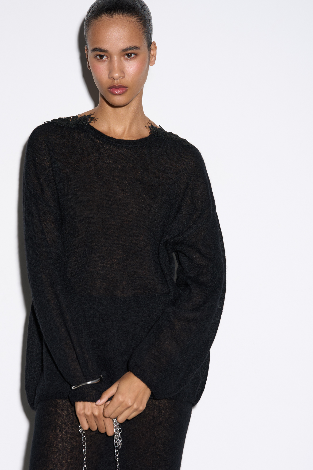 Трикотажный полупрозрачный джемпер из шерсти мериноса экстрафайн и альпака экстрафайн. Модель свободного силуэта со спущенной линией плеча и V-образным вырезом на спинке, декорированным кружевом.