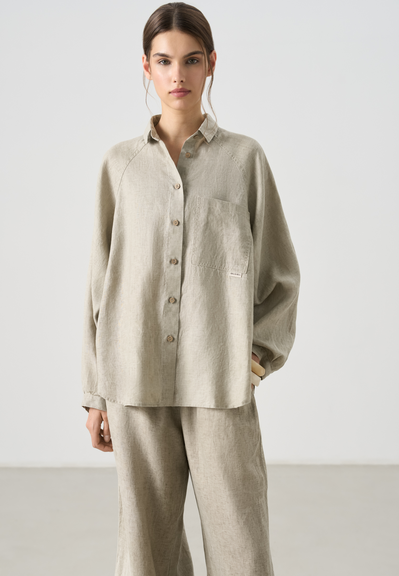 Рубашка из 100% льна. Модель свободного кроя, с длинным рукавом реглан, отложным воротником, нагрудным карманом и удлиненной спинкой. Застежка на пуговицы.