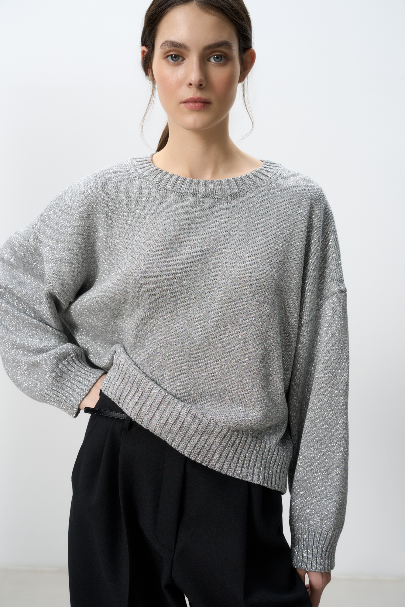 Трикотажный джемпер из вискозы с добавлением люрекса. Модель свободного силуэта с круглым вырезом горловины и спущенной линией плеча.