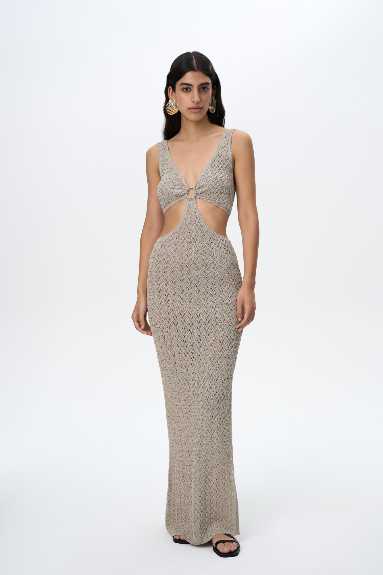 Трикотажный ажурный сарафан из вискозы длины макси. Модель декорирована кольцом, которое соединяет декольте с V-образным вырезом и юбку изделия. Без подкладки.