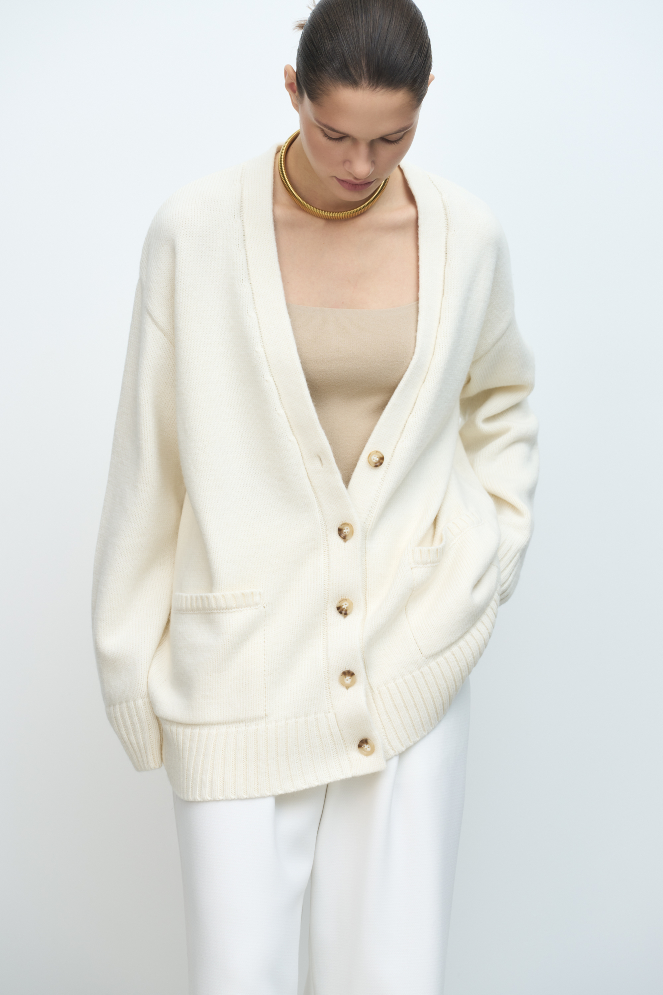 Трикотажный кардиган из шерсти альпака. Модель свободного силуэта с V-образным вырезом и накладными карманами. Края изделия в рубчик.