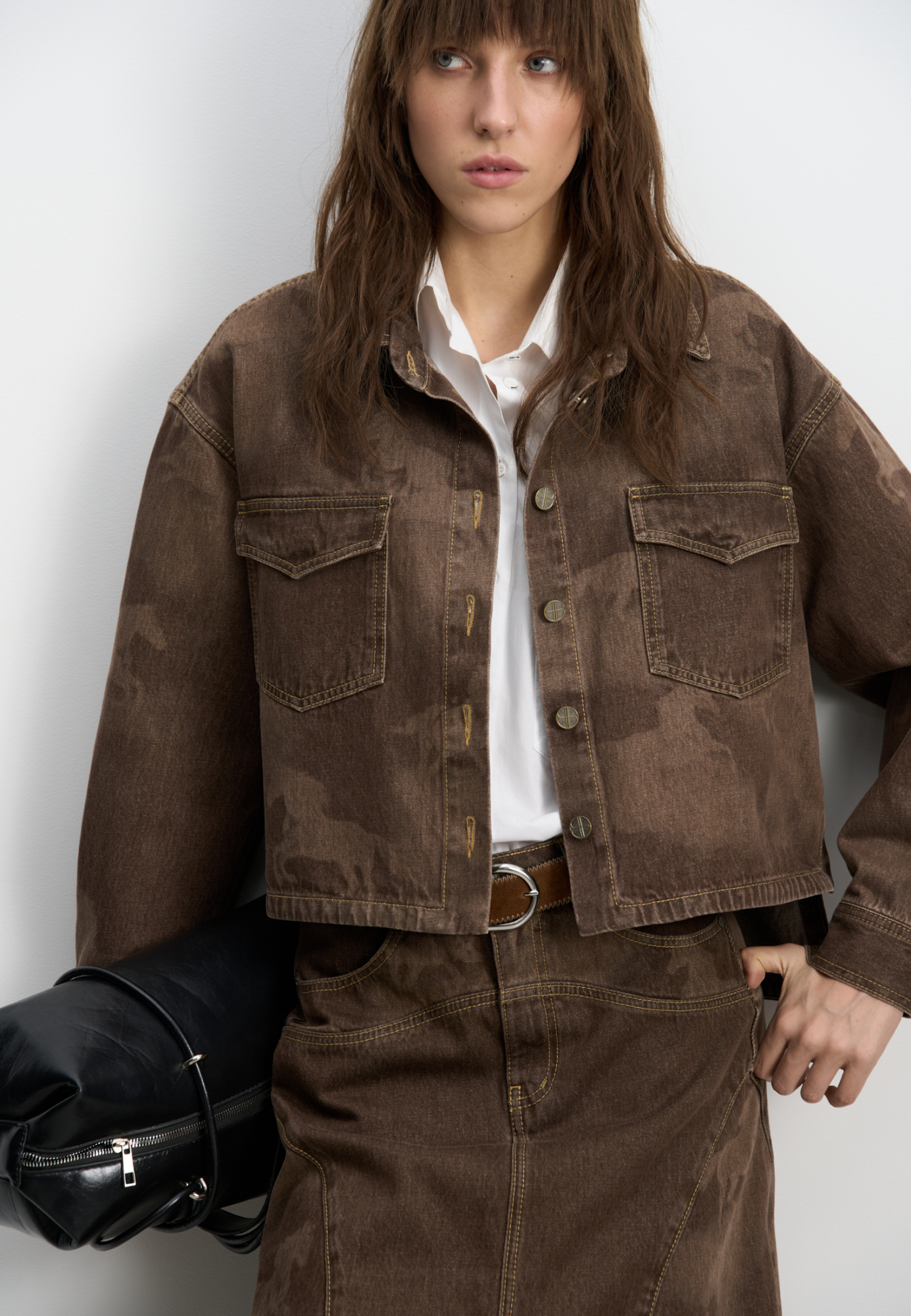 Джинсовая рубашка из 100% хлопка с принтом лошадей. Модель укороченного силуэта&nbsp;&nbsp;с длинными рукавами, классическим отложным воротником, нагрудными карманами с клапанами и застежкой на металлические пуговицы с логотипом бренда. Изделие декорировано принтом лошадей, выполненным лазером, и объемными геометрическими вытачками.<br />
Модель в стиле дерби - направления в моде, которое имитирует одежду для скачек.