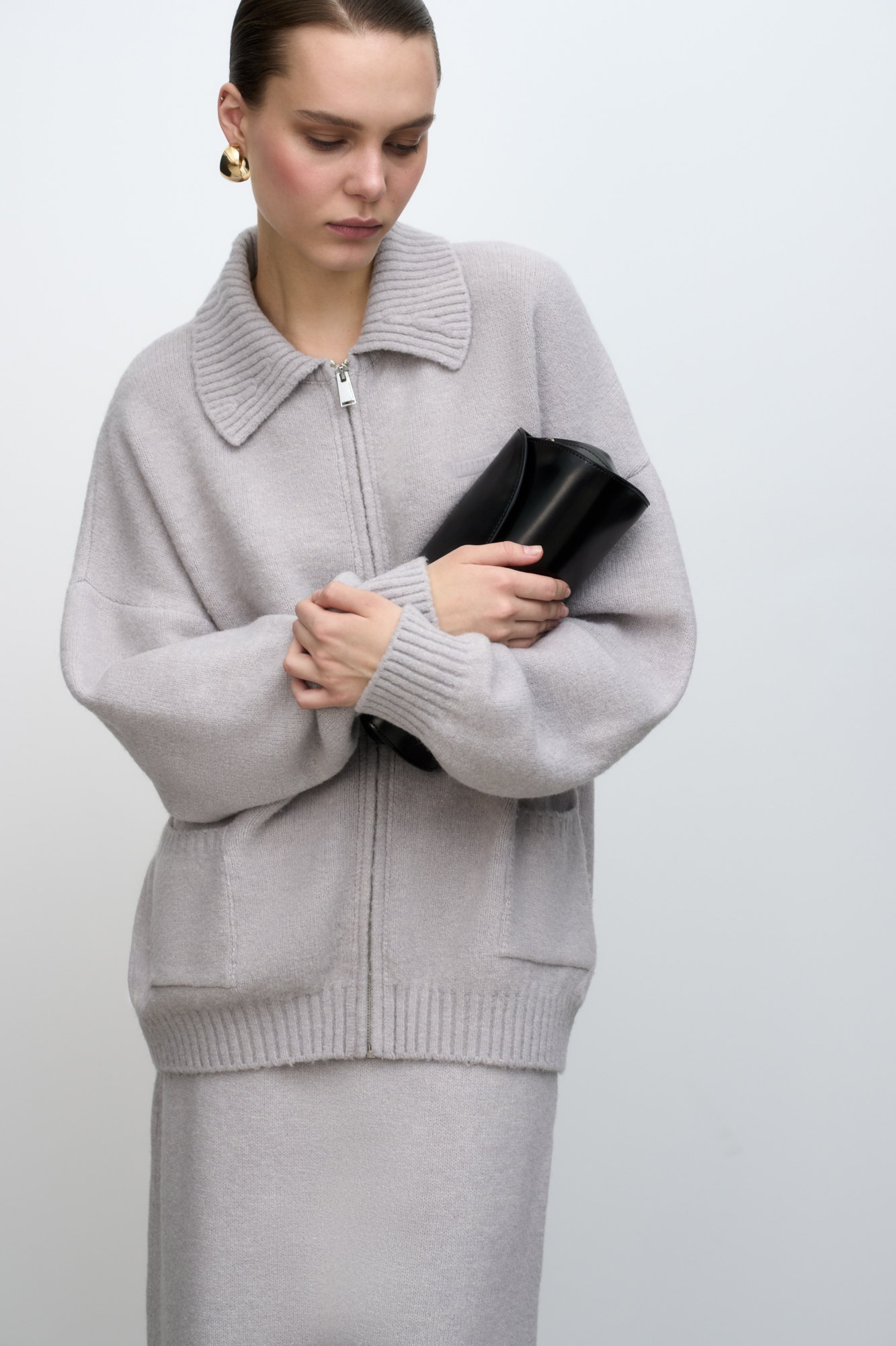 Трикотажный бомбер из шерсти с добавлением мохера. Модель свободного силуэта со спущенной линией плеча, отложным воротником и накладными карманами. Застежка на молнию. Изделие без подкладки.