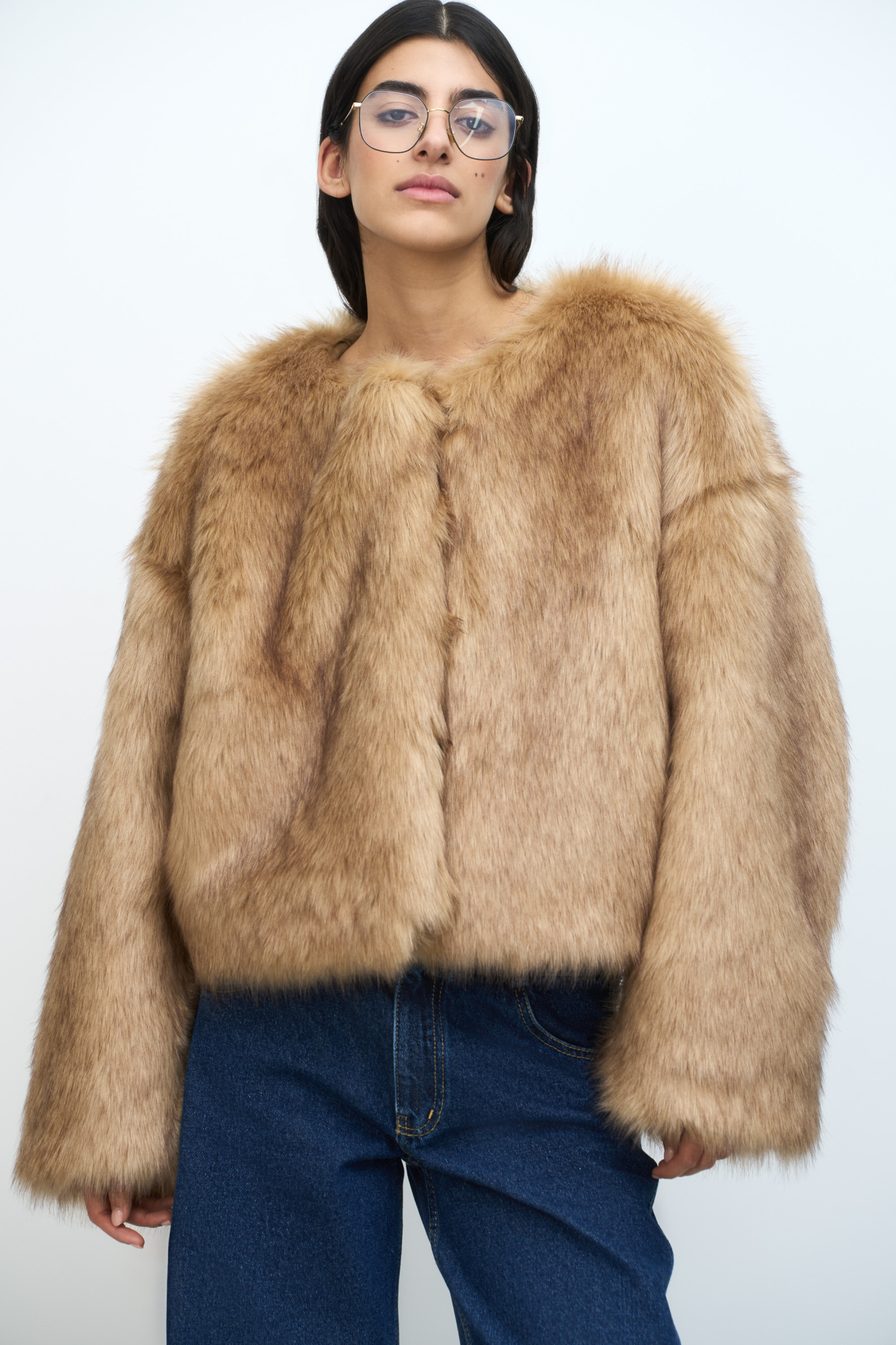 Легкая шуба из искусственного меха со спущенной линией плеча. Круглый вырез. Застежка на крючки.