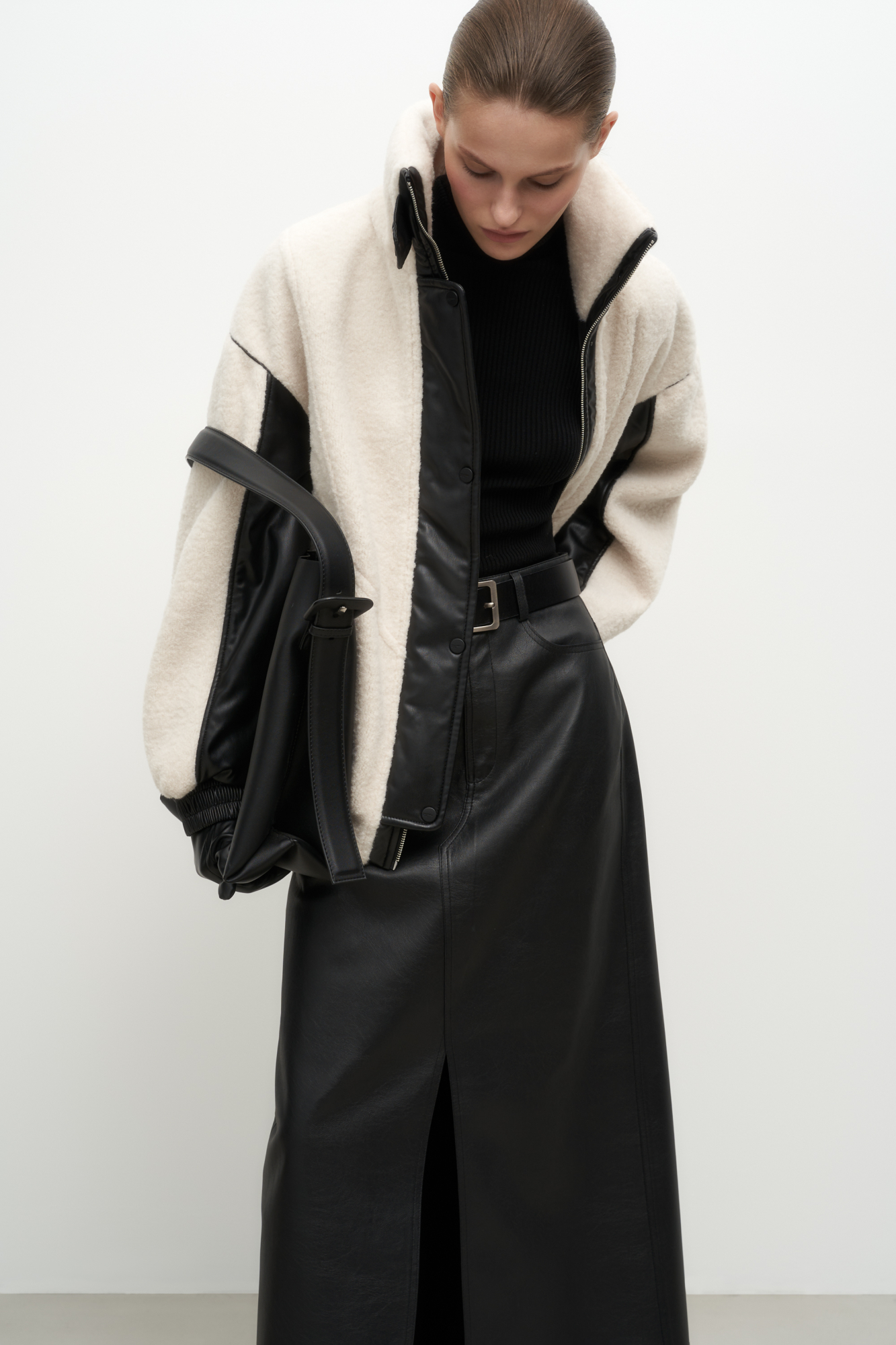 Утепленная куртка из экомеха. Модель свободного силуэта, декорированная вставками из экокожи и брендированным ярлыком на спине. Воротник-стойка, боковые карманы, застежка на молнию и кнопки. Манжеты и низ изделия на резинке. На подкладке.