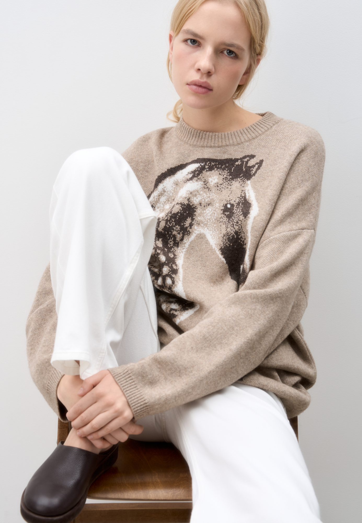 Трикотажный джемпер из шерсти и кашемира. Модель свободного силуэта со спущенной линией плеч, круглым вырезом горловины и жаккардовым анималистичным принтом лошади. Края изделия выполнены в рубчик.