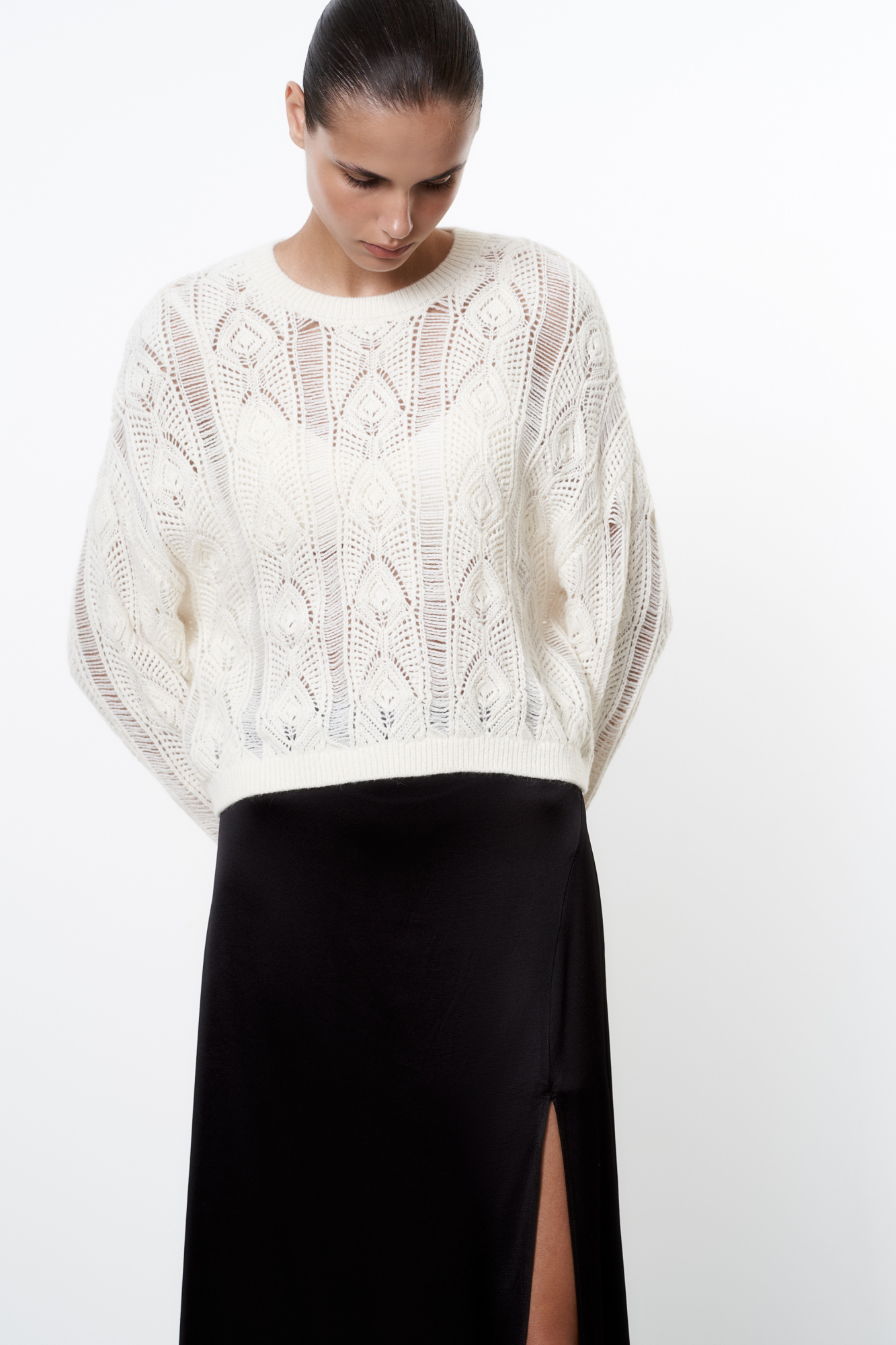 Трикотажный джемпер из шерсти альпака ажурной вязки. Модель свободного силуэта со спущенной линией плеч и круглым вырезом горловины. Манжеты и низ изделия выполнены в рубчик.