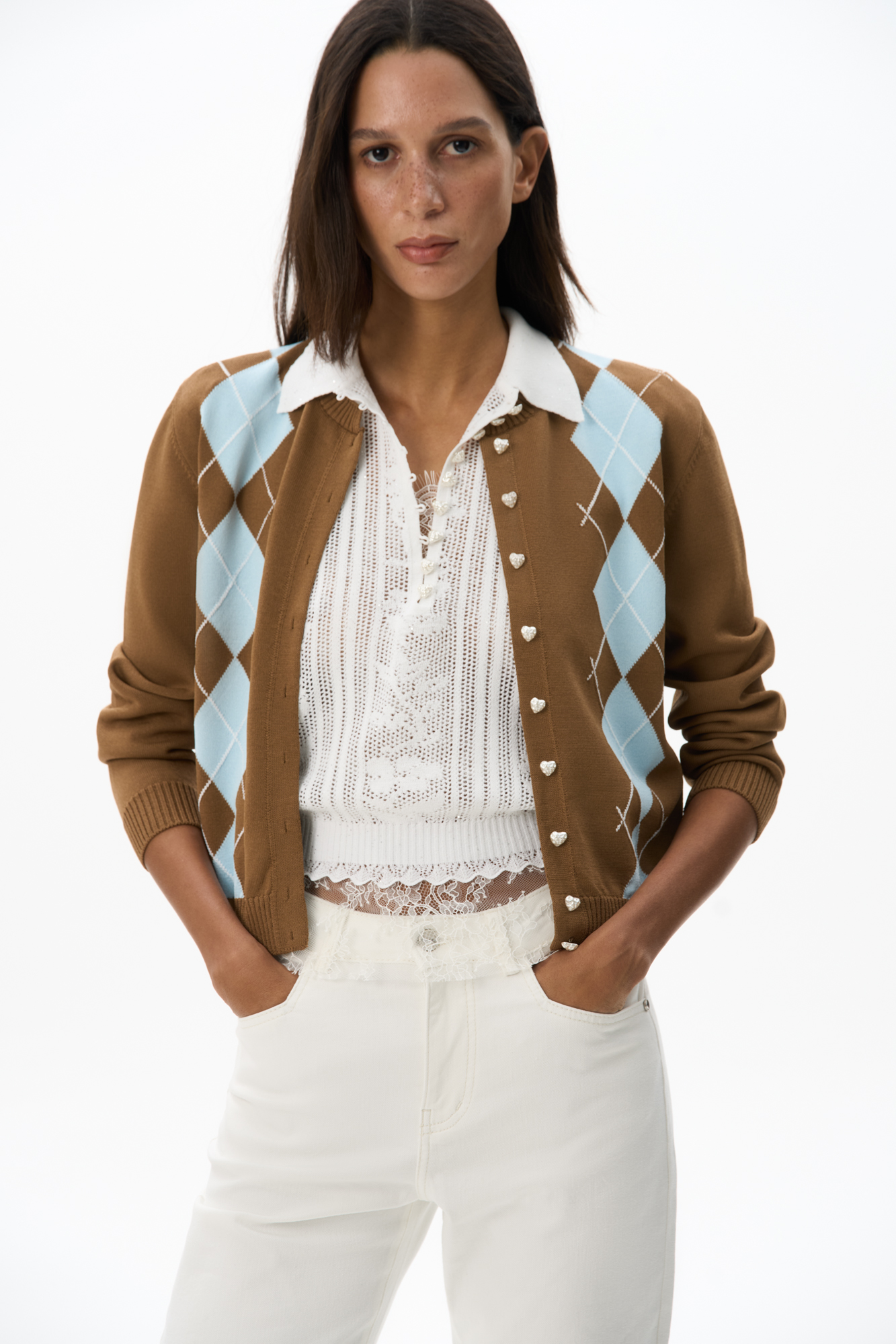 Трикотажный кардиган из вискозы с узором аргайл. Модель свободного силуэта с длинными рукавами, круглым вырезом горловины и застежкой на пуговицы-сердечки. Края изделия выполнены в рубчик.