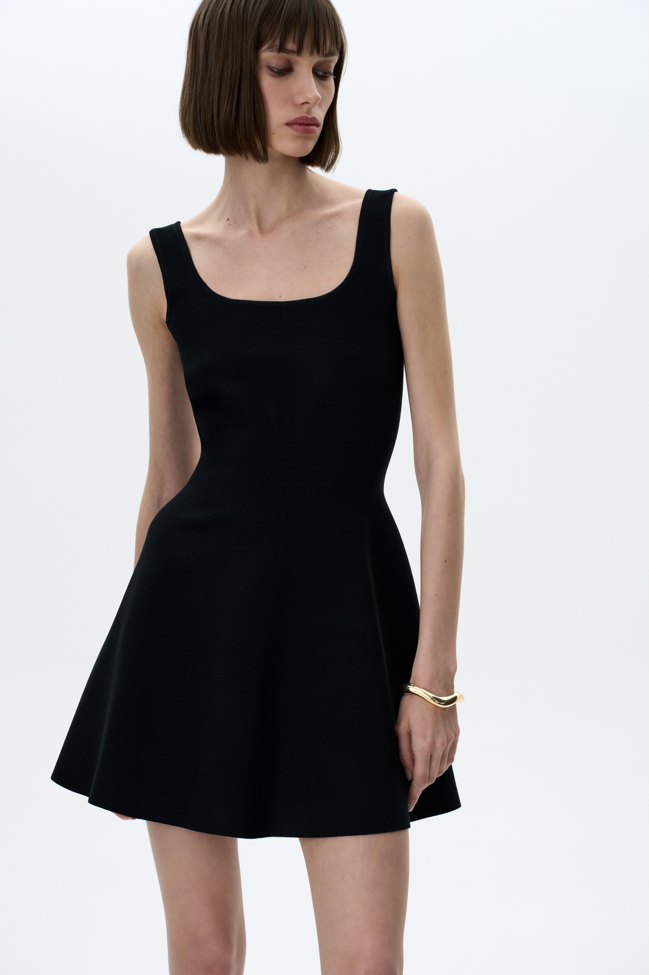 Трикотажное мини платье в стиле baby doll на широких бретелях. Круглый вырез, застежка сзади на молнию. Платье связано из плотной эластичной вискозы, что позволяет прилегать по фигуре и держать объем у юбки.