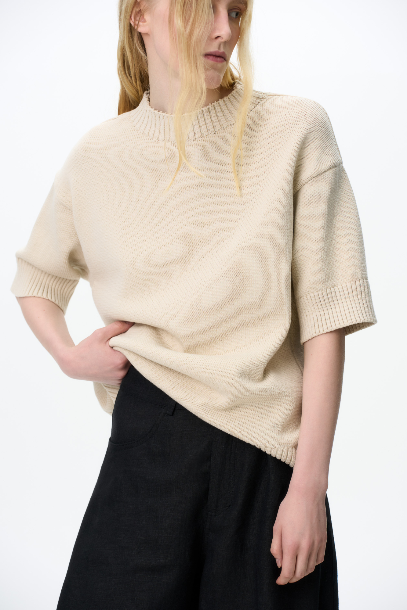 Трикотажная футболка из хлопка. Модель свободного силуэта со спущенной линией плеча, коротким рукавом и круглым вырезом горловины. Воротник, манжеты рукавов и низ изделия выполнены в широкий рубчик.