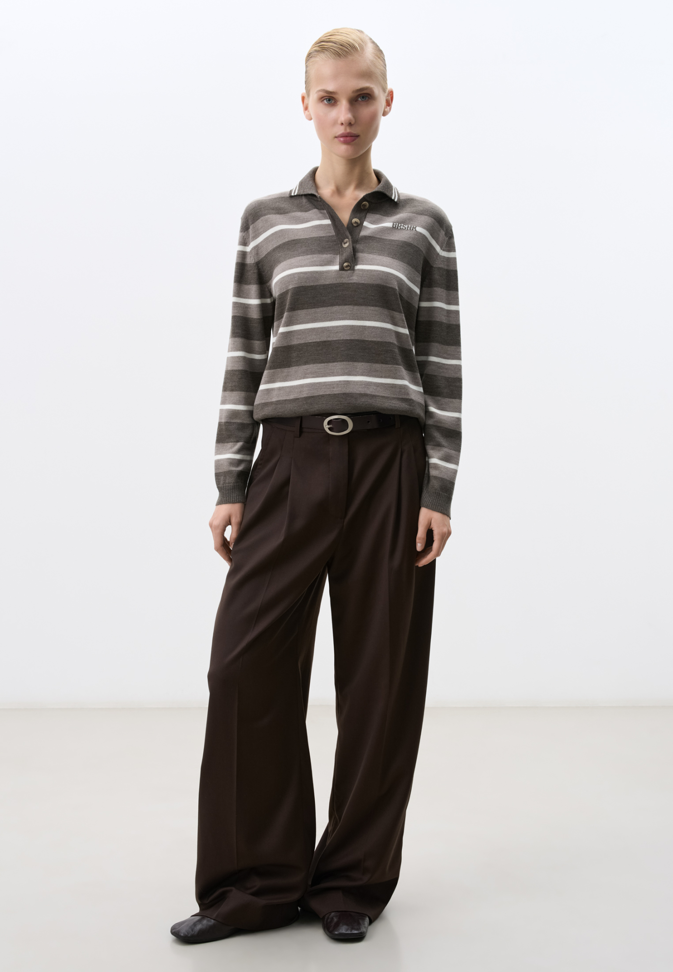 Трикотажный джемпер из шерсти в полоску. Модель свободного силуэта, с длинными рукавами, воротником поло на пуговицах и брендированным жаккардом на груди. Манжеты, воротничок и низ изделия выполнены в рубчик.