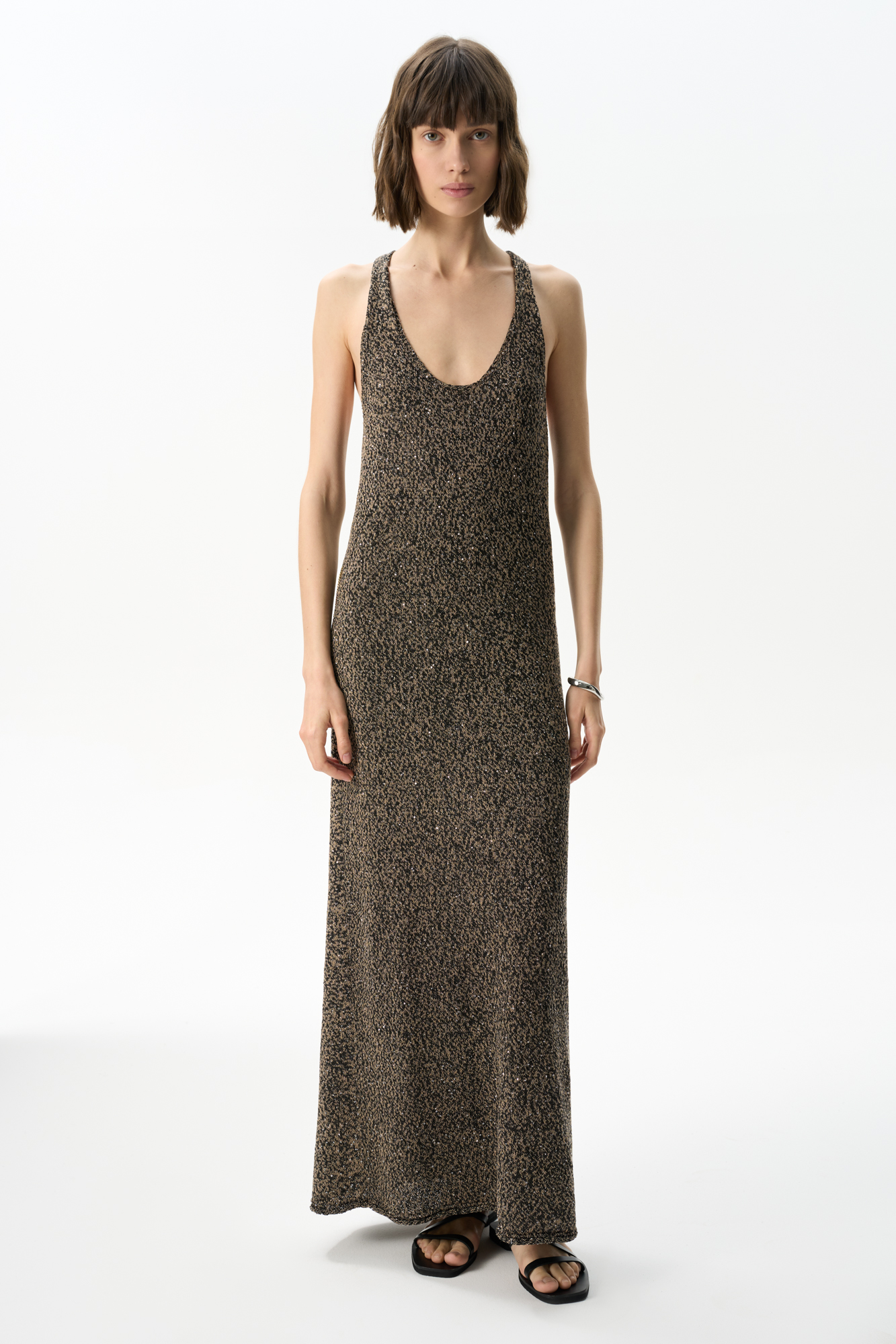 Трикотажный сарафан длины макси из хлопка с пайетками. Модель свободного кроя, на широких бретелях с перекрутом на спине и глубоким U-образным вырезом. 