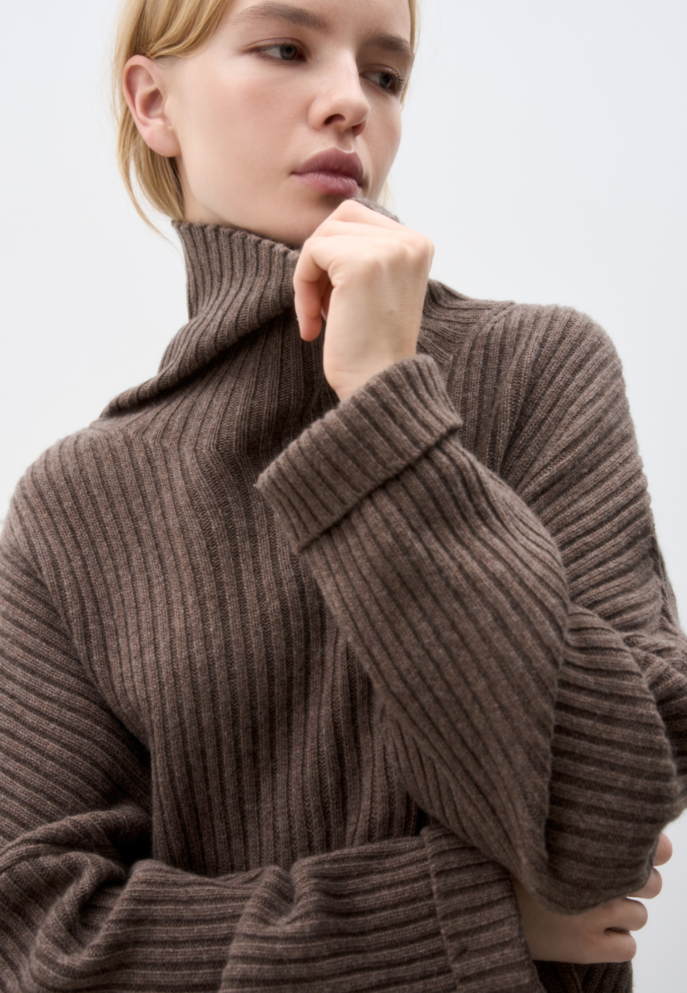 Широкий трикотажный джемпер из шерсти с добавлением кашемира. Модель свободного силуэта, со спущенной линией плеча, отворотами на манжетах и высоким свободным воротником.