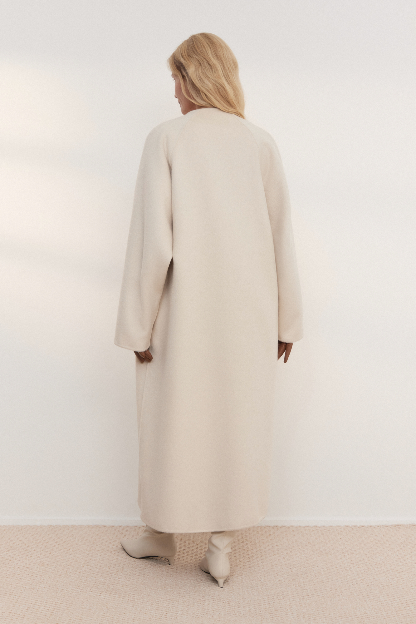 Шерстяное пальто из двусторонней ткани. Модель прямого кроя без воротника. Застежка на скрытые магнитные пуговицы. Изделие без подкладки. Модель декорирована асимметричным лацканом. Пояс из экокожи в комплекте.