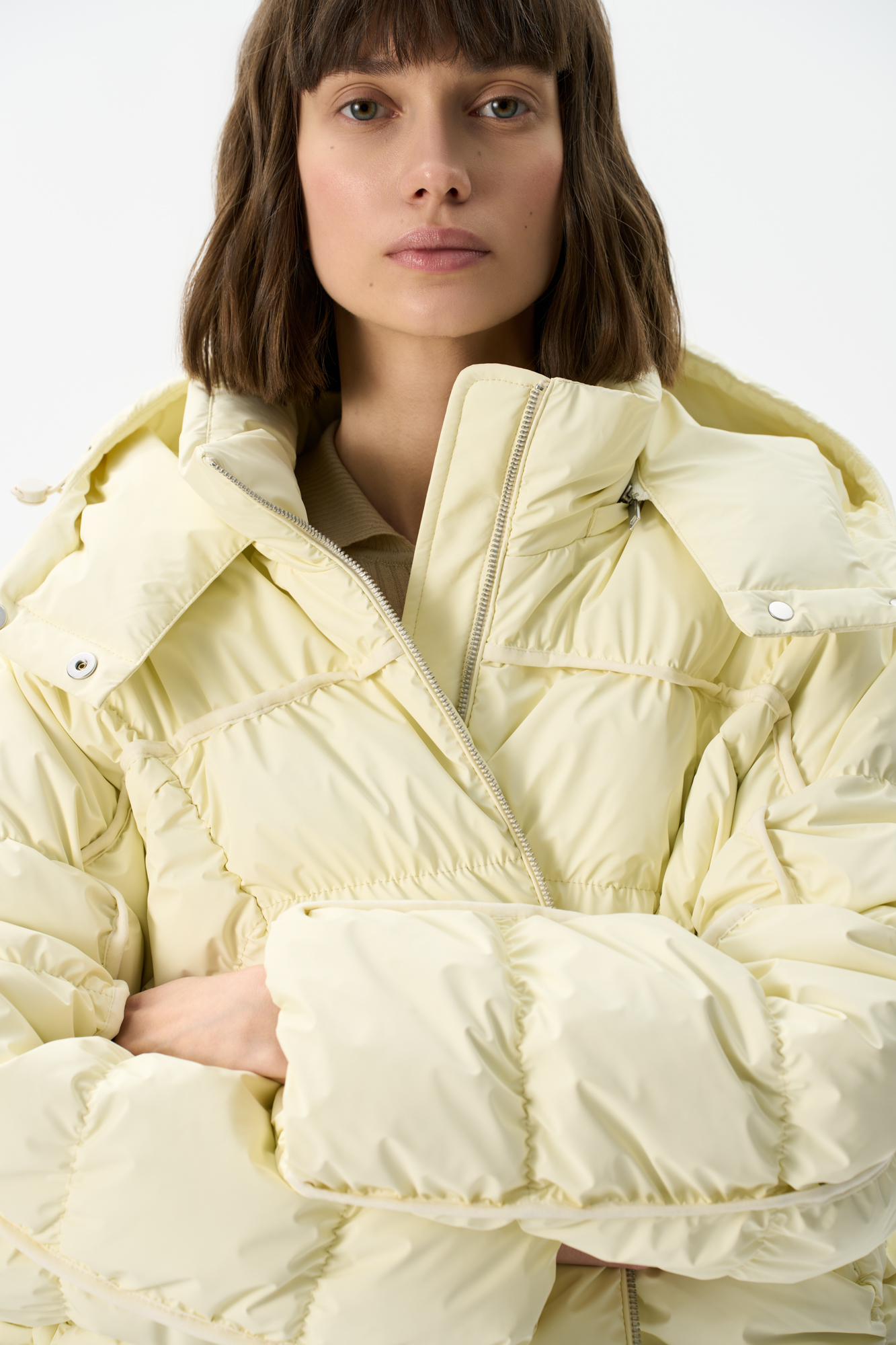 Объемный пуховик с геометрической стежкой и объемными швами. Изделие с капюшоном на кулиске и воротником-стойкой. 