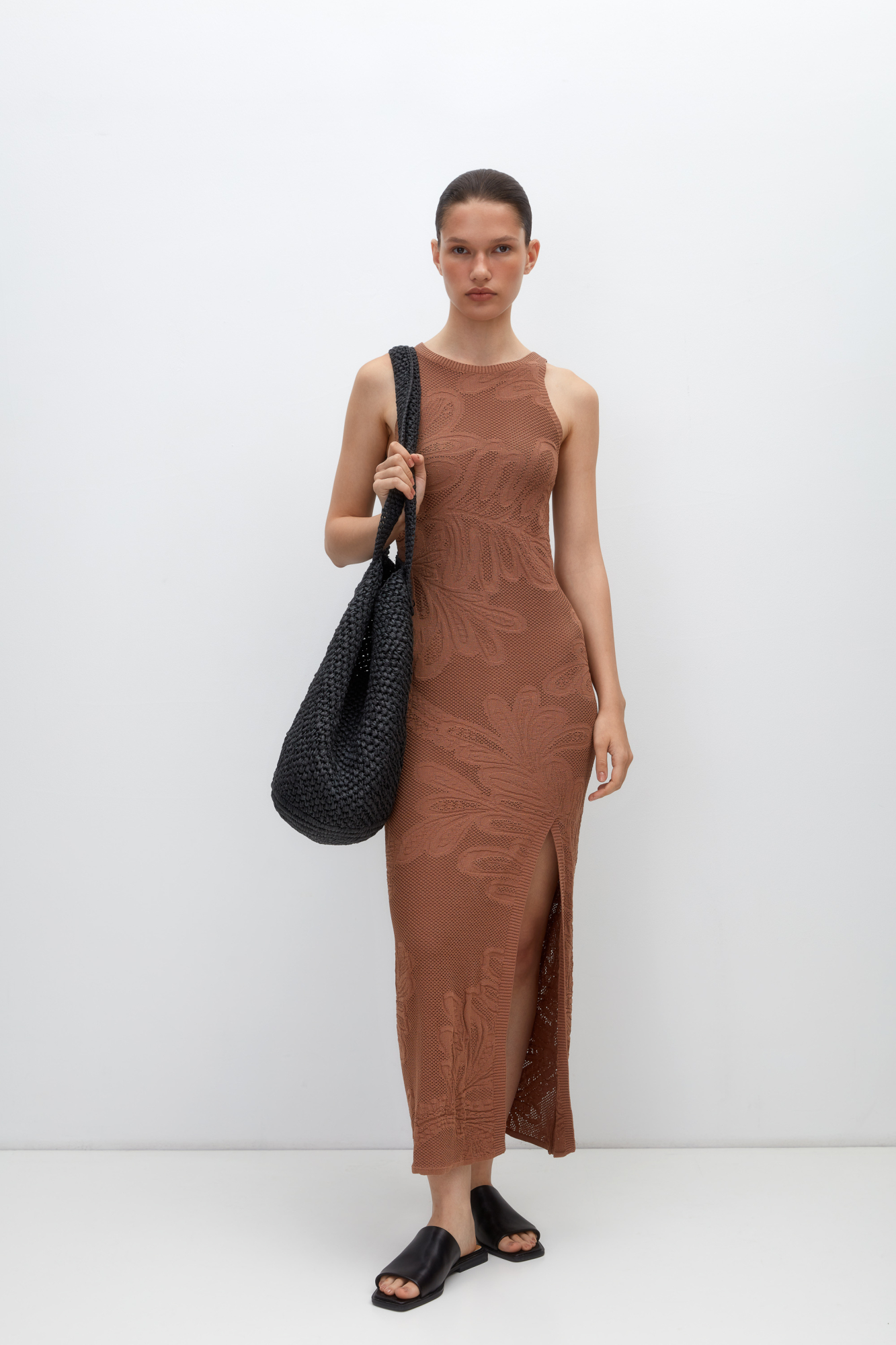 Трикотажное платье длины миди из органического хлопка. Модель приталенного силуэта, без рукавов. круглым вырезом горловины, разрезом спереди и шнуровкой на спине. Изделие декорировано растительным орнаментом. <br />
Органический хлопок - более экологичная и безопасная альтернатива обычному хлопку, выращенная без использования химикатов.