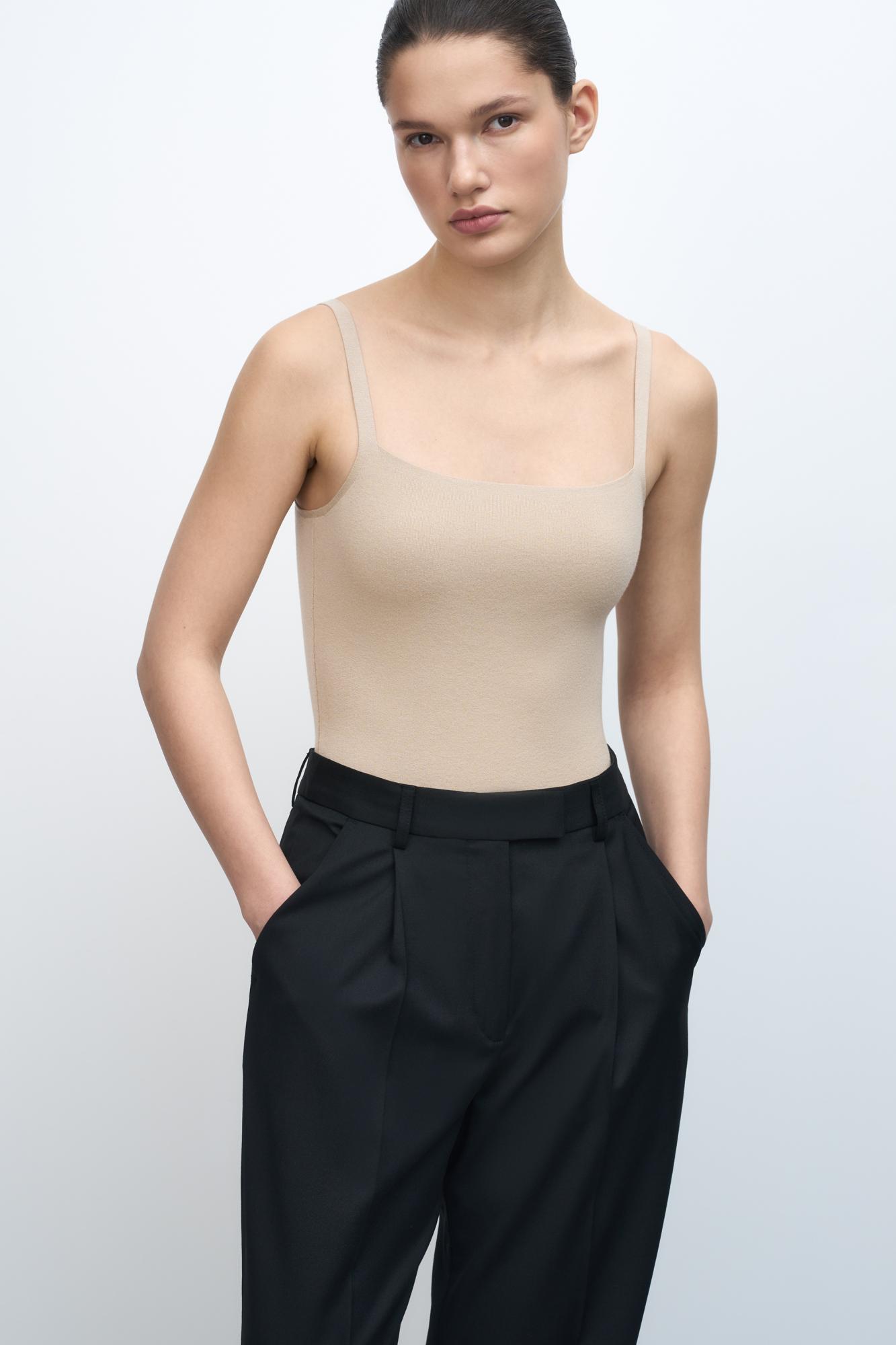 Трикотажное боди из вискозы. Модель приталенного силуэта на тонких бретелях и глубоким вырезом. Изделие застегивается на крючки.