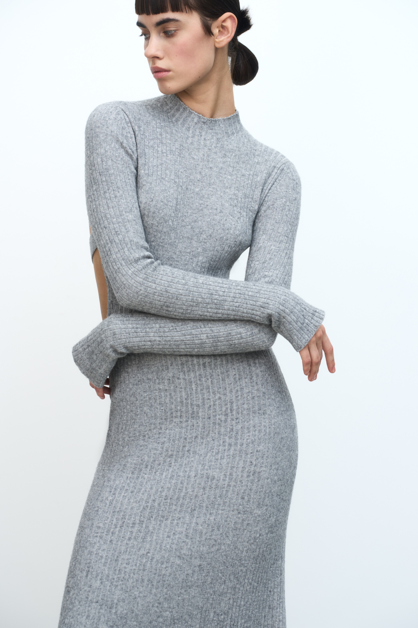 Трикотажное платье из кашемира и шерсти. Модель приталенного силуэта с длинными рукавами, расклешенными рукавами и невысоким воротником. Изделие декорировано глубоким вырезом на спине.