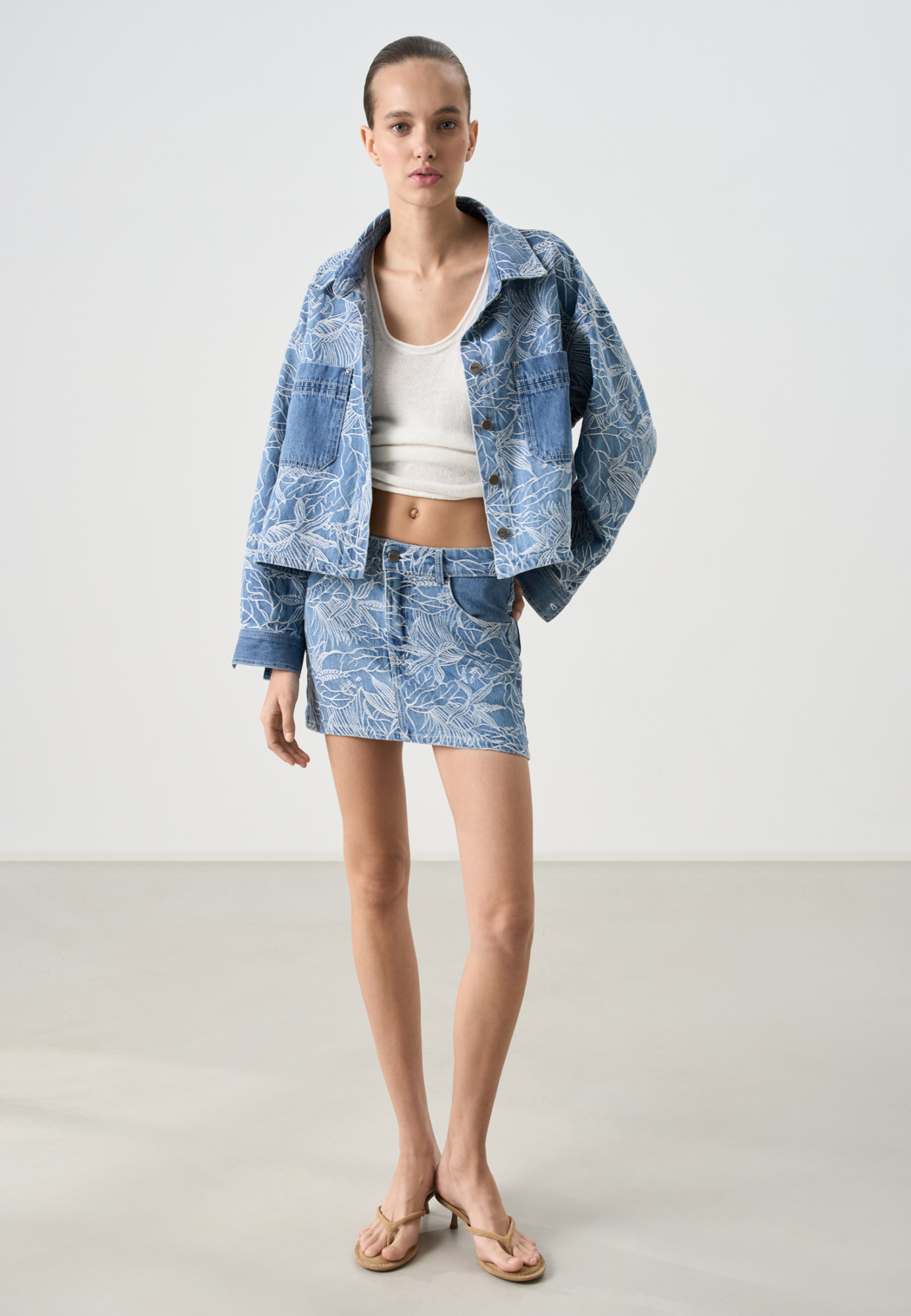 Принтованная джинсовая юбка длины мини из 100% хлопка. Модель прямого кроя, с вертикальными вытачками, шлевками на поясе для ремня, карманами контрастного цвета. Застежка на молнию и пуговицу.