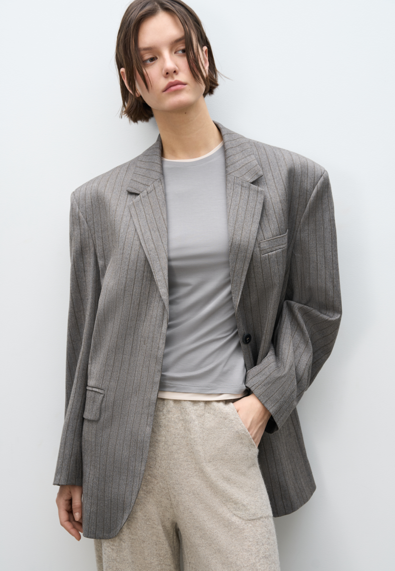 Однобортный жакет в полоску. Модель прямого кроя, с узкими лацканами, нагрудным карманом, боковыми карманами с клапанами и пуговицами на рукавах. Застежка на скрытые пуговицы под планкой. Изделие выполнено на подкладке.