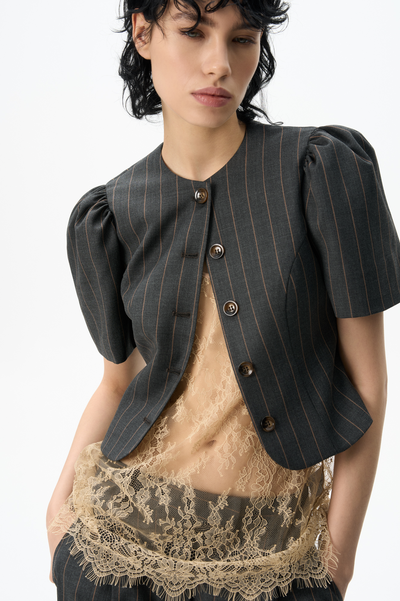 Однобортный жакет без лацканов. Модель приталенного силуэта с вытачками по фигруе и короткими рукавами-фонариками. Застежка на пуговицы. Изделие выполнено на подкладке.