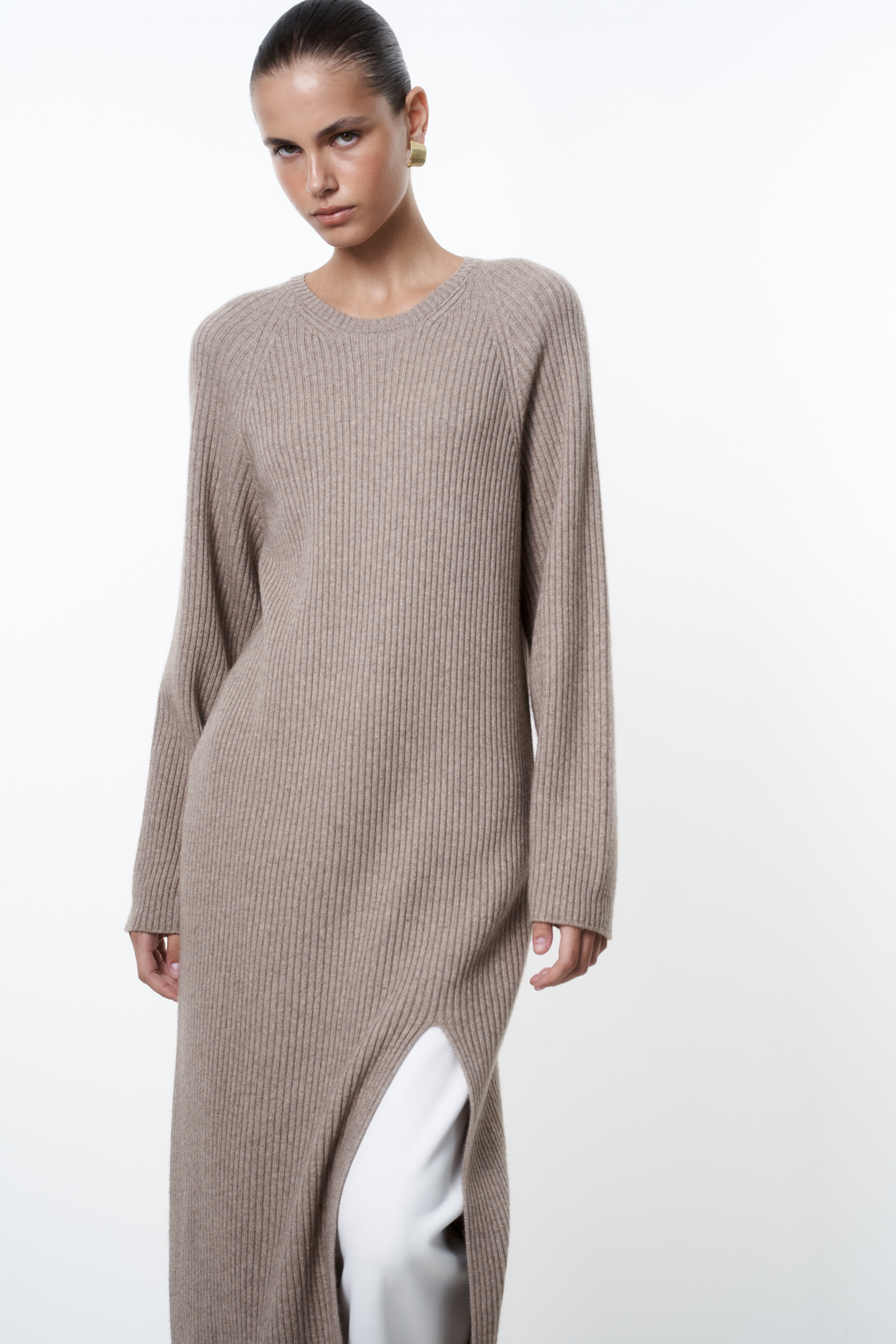 Трикотажное платье из шерсти и кашемира. Модель свободного силуэта в широкий рубчик с разрезом спереди и спущенной линией плеча. 