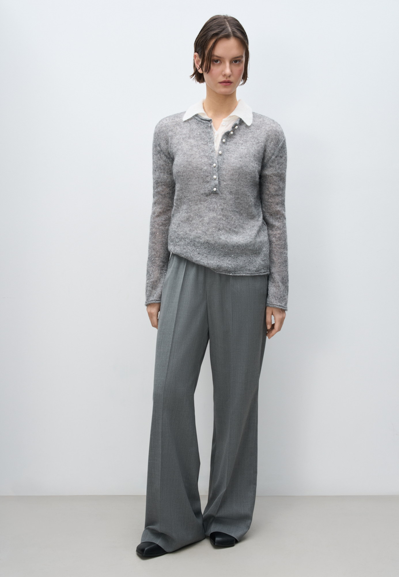 Трикотажный лонгслив из кидмохера, декорированный мелкими пайетками. Модель с круглым вырезом горловины с планкой на пуговицах. Края изделия декорированы валиком.