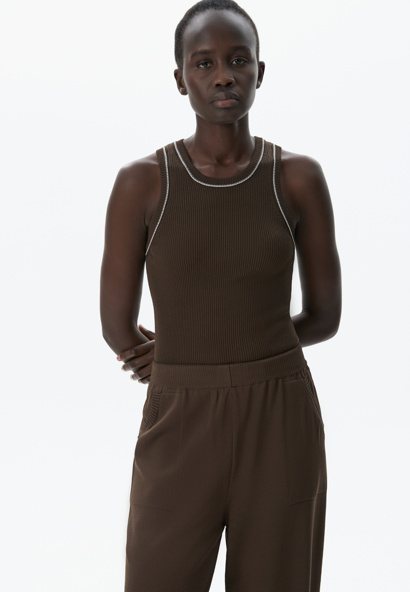 Трикотажный топ из вискозы в рубчик. Модель приталенного силуэта, без рукавов и круглым вырезом горловины. Изделие декорировано строчкой контрастного цвета.
