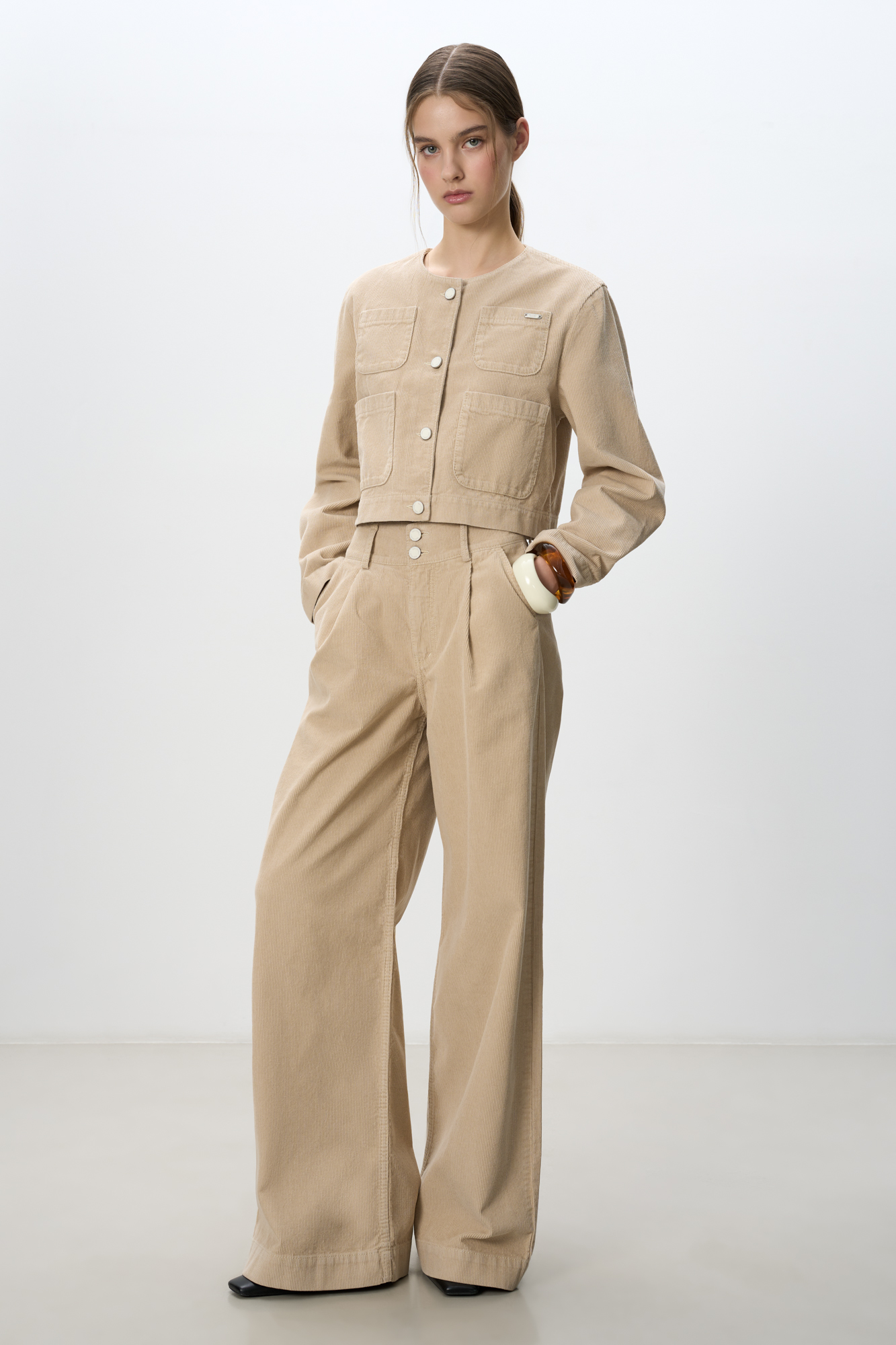 Вельветовые брюки из 100% хлопка с высокой посадкой. Модель с широким поясом и шлевками для ремня, сзади пояс выполнен на резинке. Застежка на две металлические пуговицы и молнию. Дополнить образ можно жакетом.