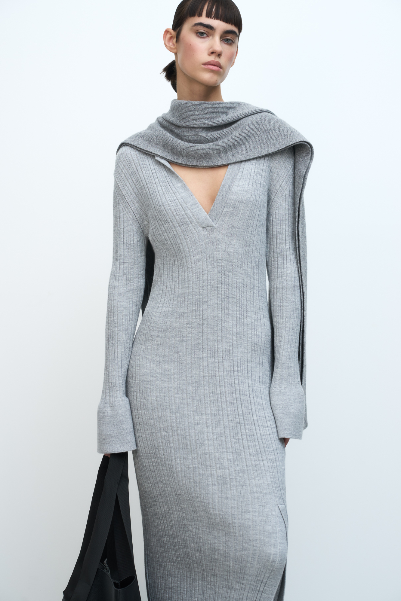 Трикотажное платье из шерсти. Модель приталенного силуэта, длины миди с V-образным вырезом, воротником поло и разрезом спереди.