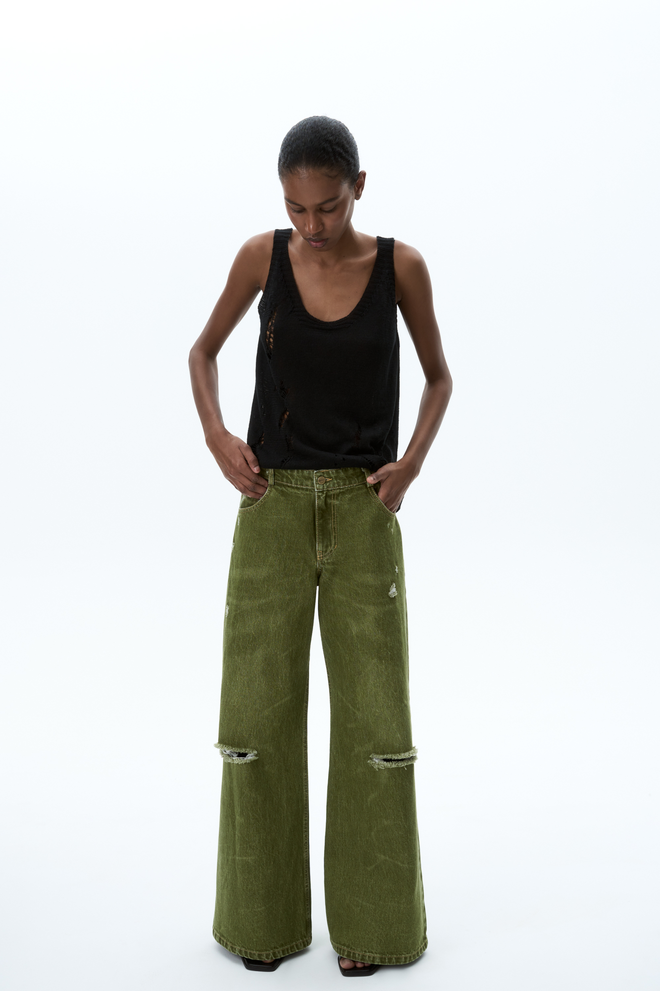 Широкие джинсы из 100% хлопка с горизонтальными разрезами. Модель прямого силуэта, со средней посадкой. Пять карманов, шлевки на поясе для ремня, застежка на молнию и пуговицу.