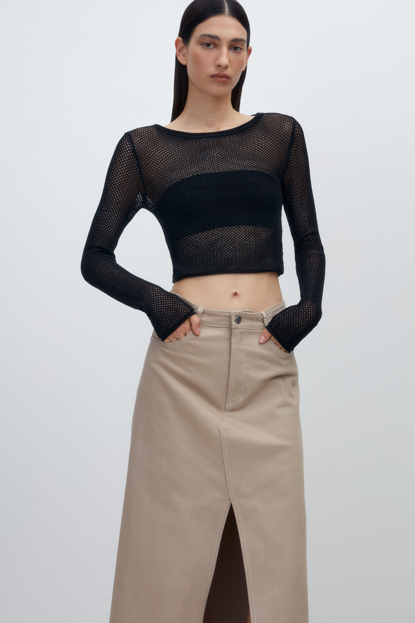 Трикотажный топ из вискозы. Модель прямого силуэта, с длинными рукавами и круглым вырезом горловины. Изделие выполнено ажурной вязкой.