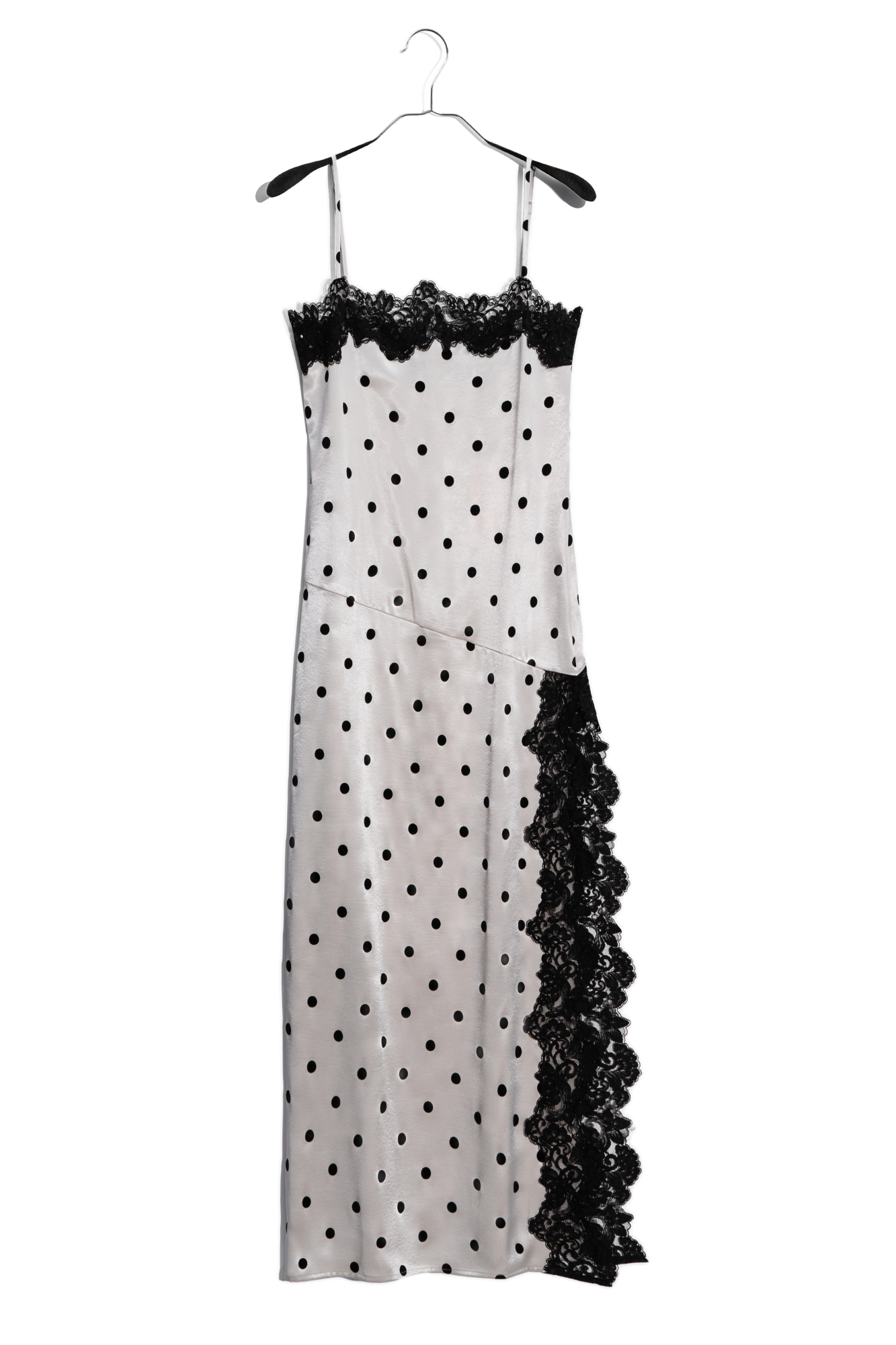 Атласное платье-комбинация длины макси в горох. Модель приталенного силуэта на тонких бретельках и высоким разрезом сбоку. Изделие декорировано кружевом.