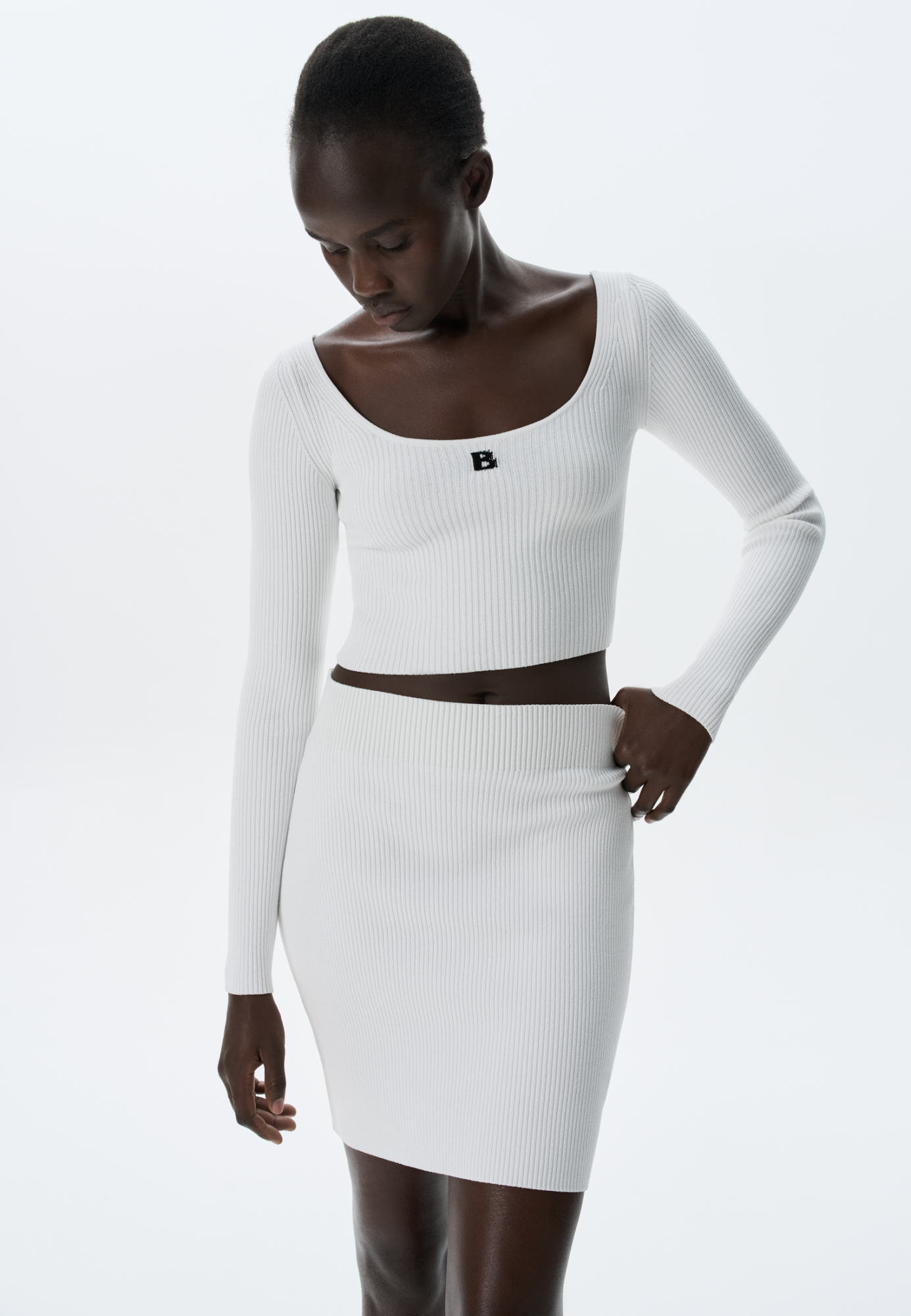 Укороченный топ из вискозы в спортивном стиле с длинными рукавами и круглым вырезом. Дополнить образ можно лосинами или юбкой.