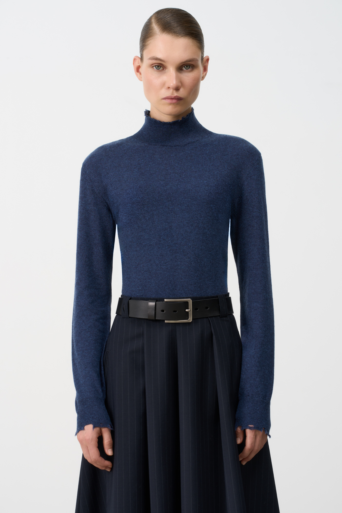 Трикотажная водолазка из шерсти с добавлением кашемира. Модель приталенного силуэта с длинным рукавом и воротником-стойкой. Манжеты рукавов, воротник и низ изделия с рваным краем.